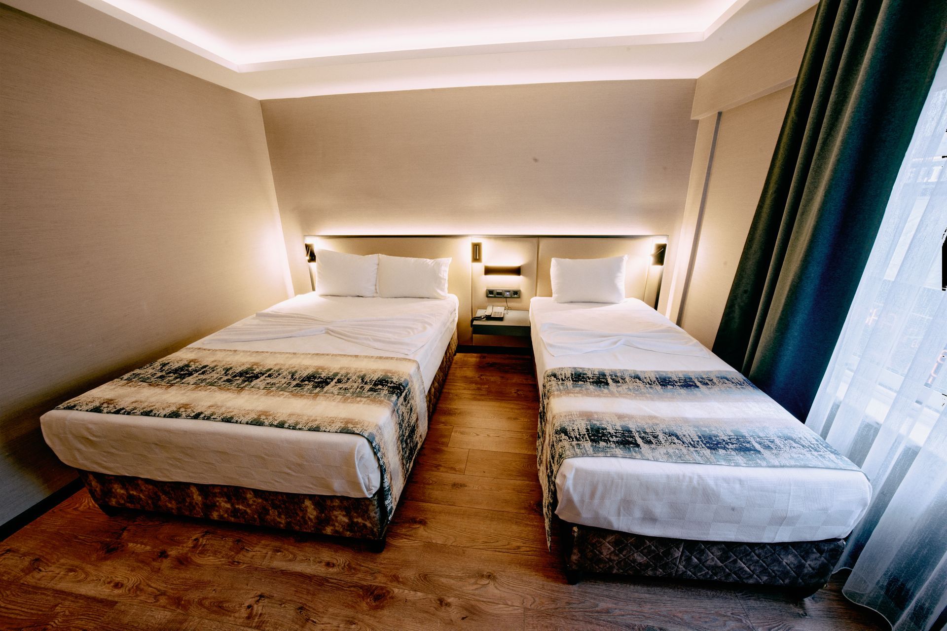 A hotel room with two beds and a window.