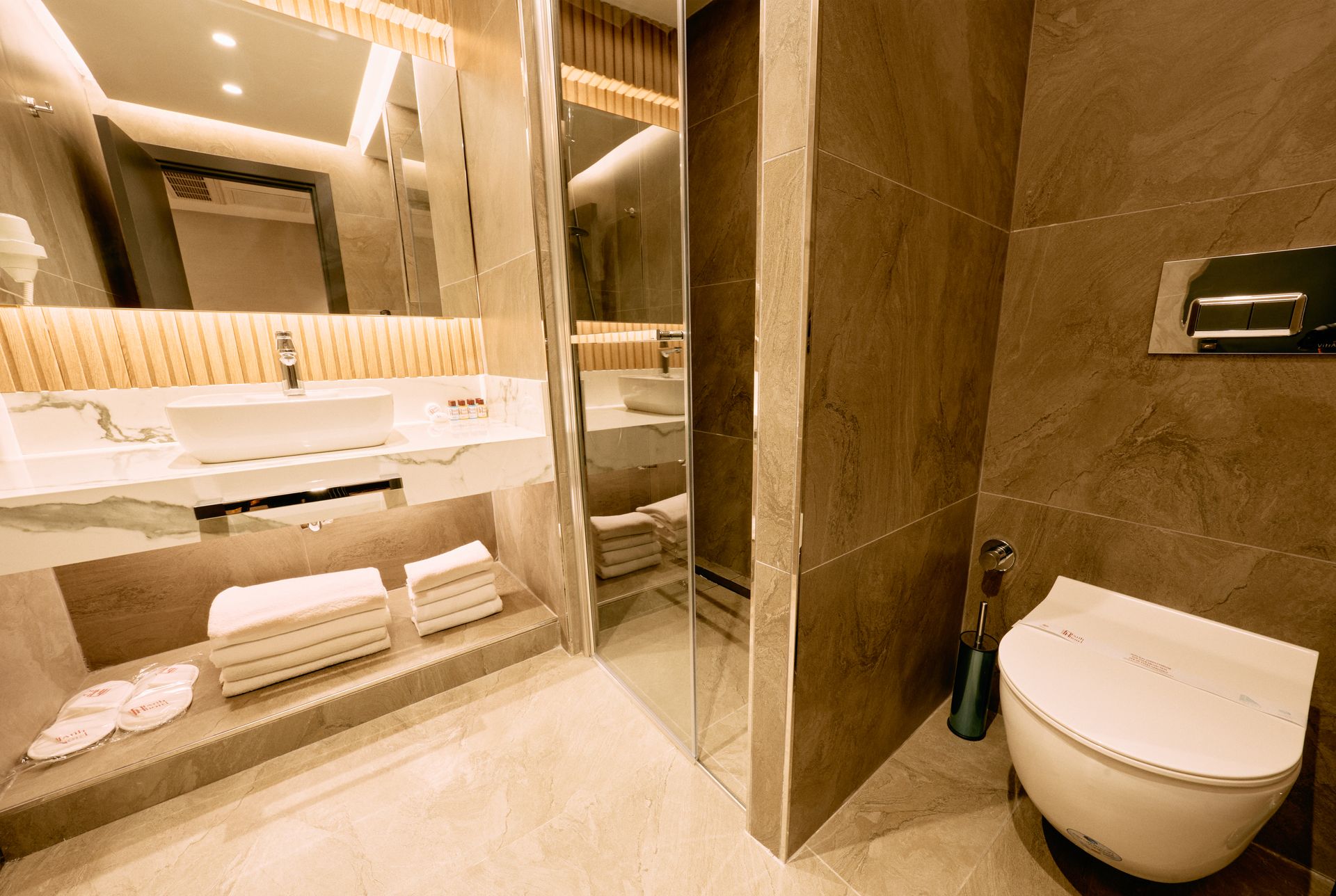 A bathroom with a toilet , sink and mirror.
