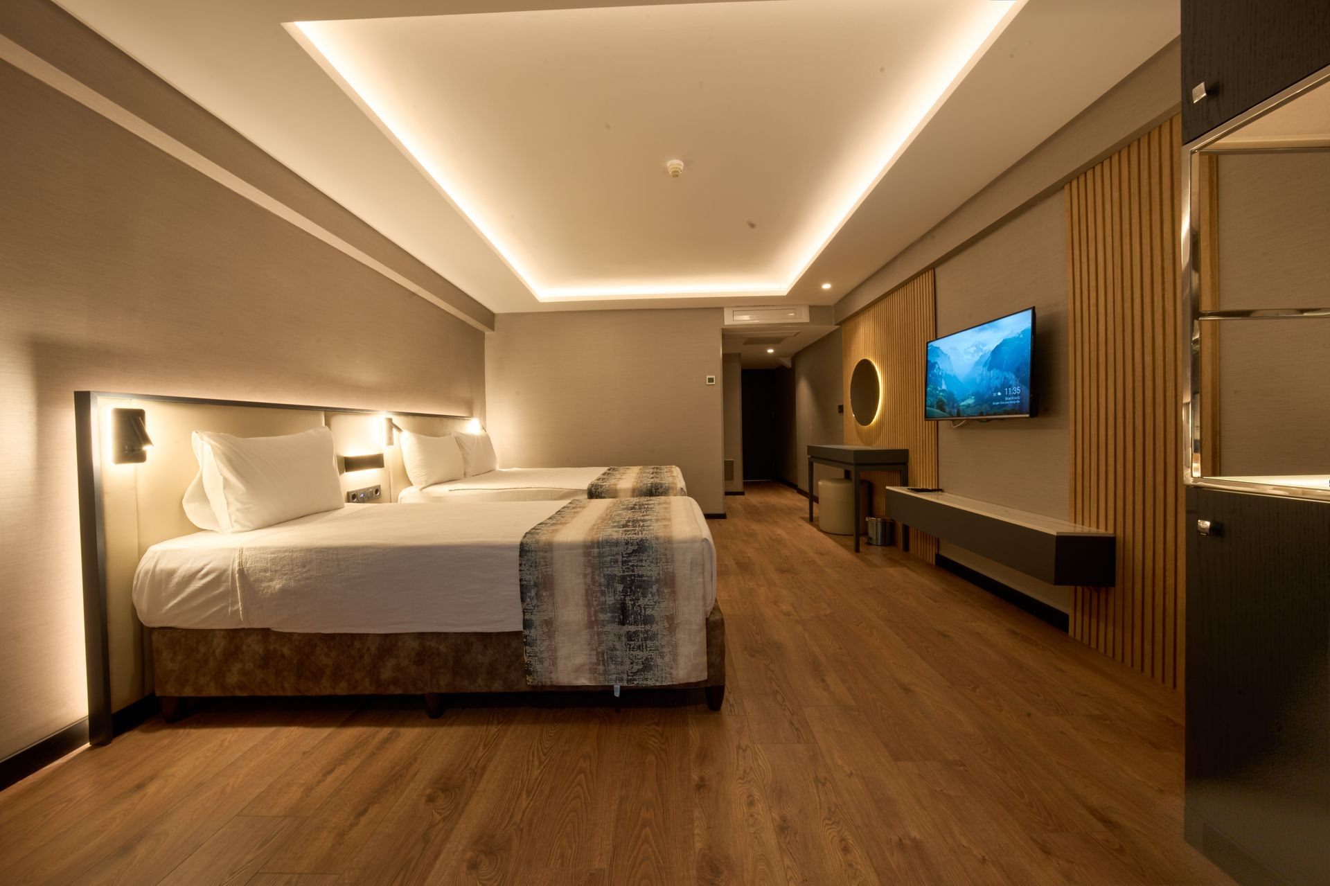 A hotel room with two beds and a flat screen tv.