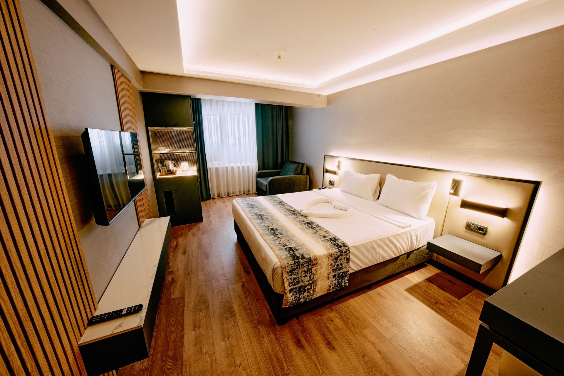 A hotel room with a large bed and a flat screen tv.
