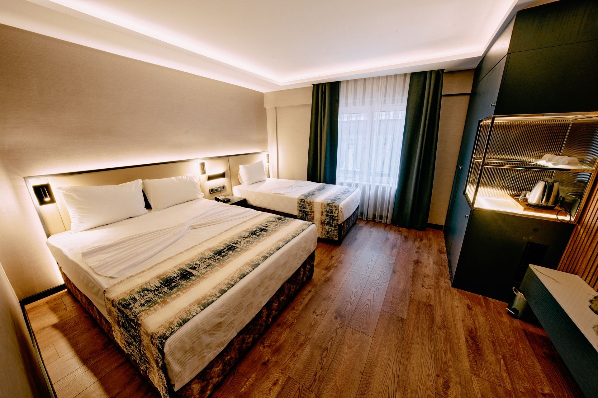 A hotel room with two beds and a window.