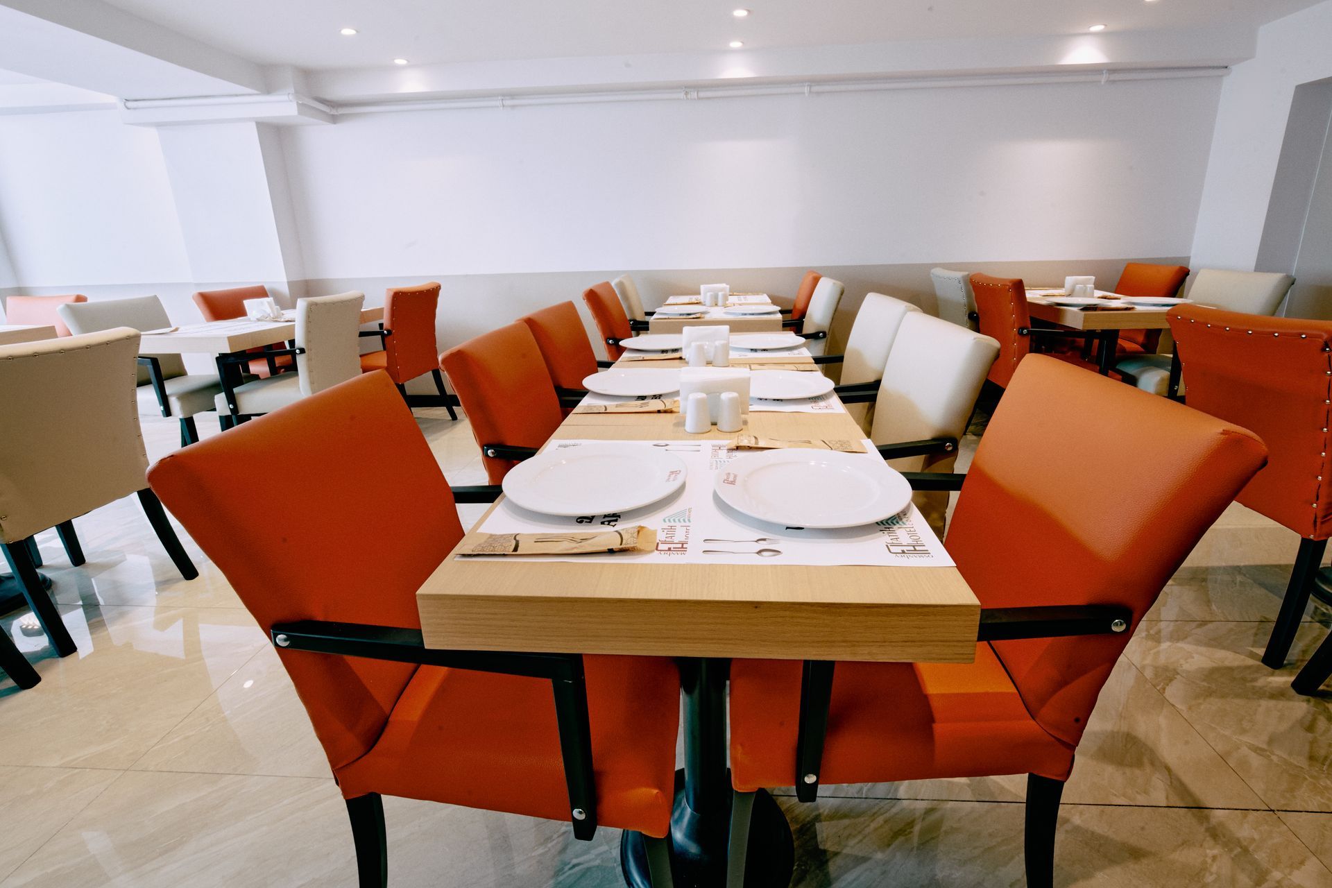 A restaurant with tables and chairs and plates on them