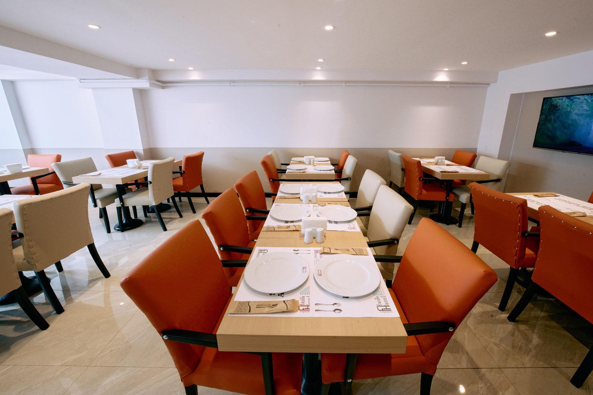 A restaurant with tables and chairs and plates on them