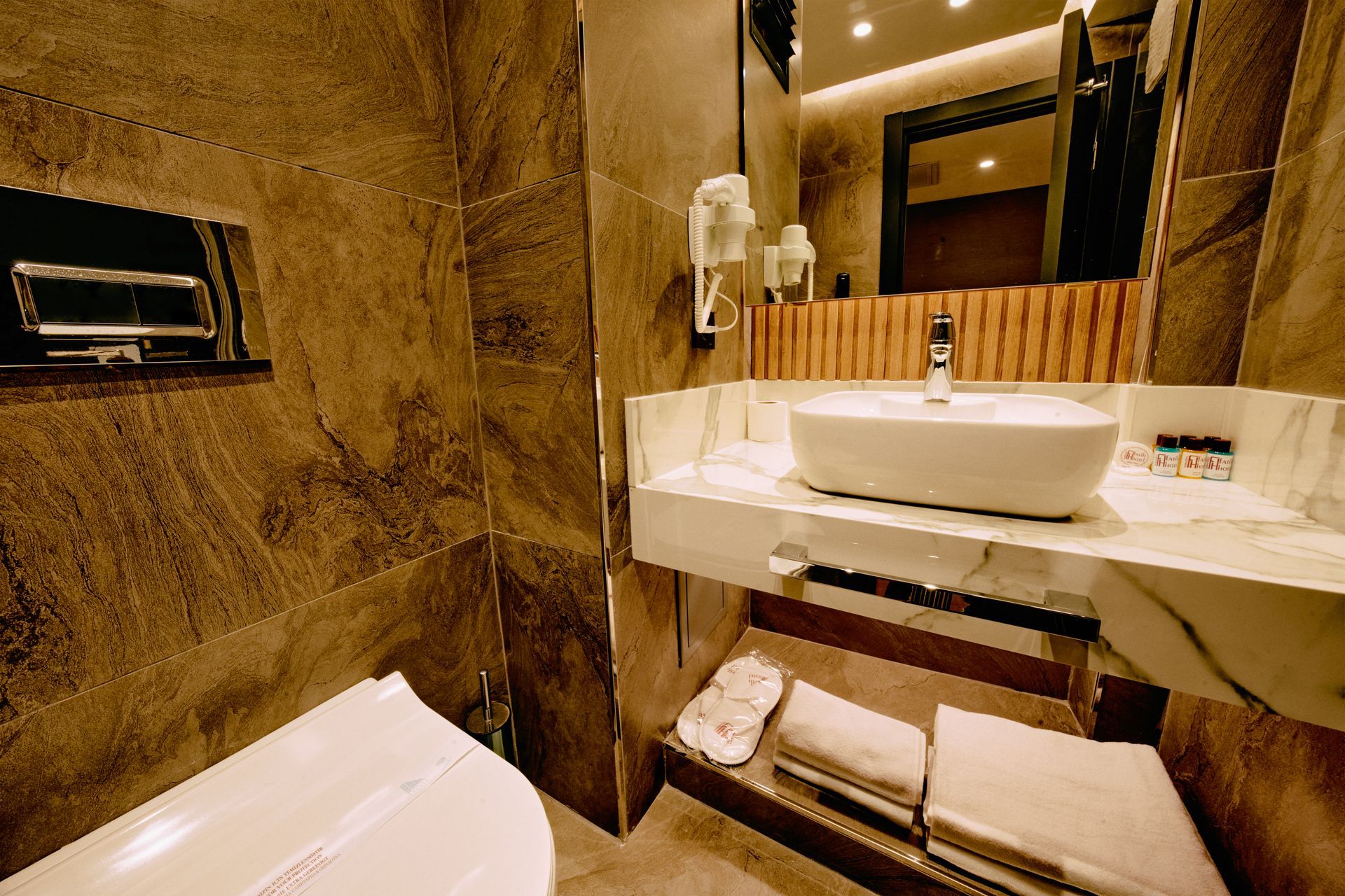 A bathroom with a sink , toilet and mirror.
