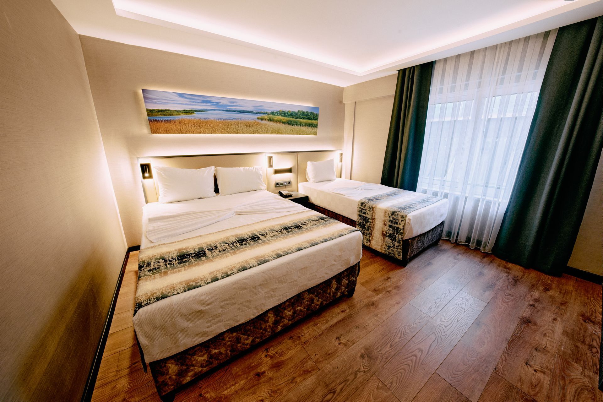 A hotel room with two beds and a large window.