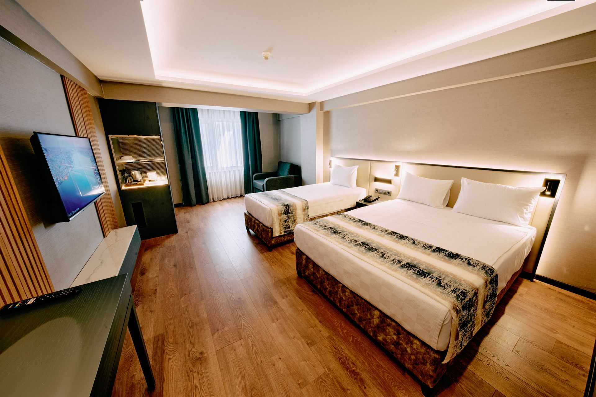 A hotel room with two beds and a flat screen tv.