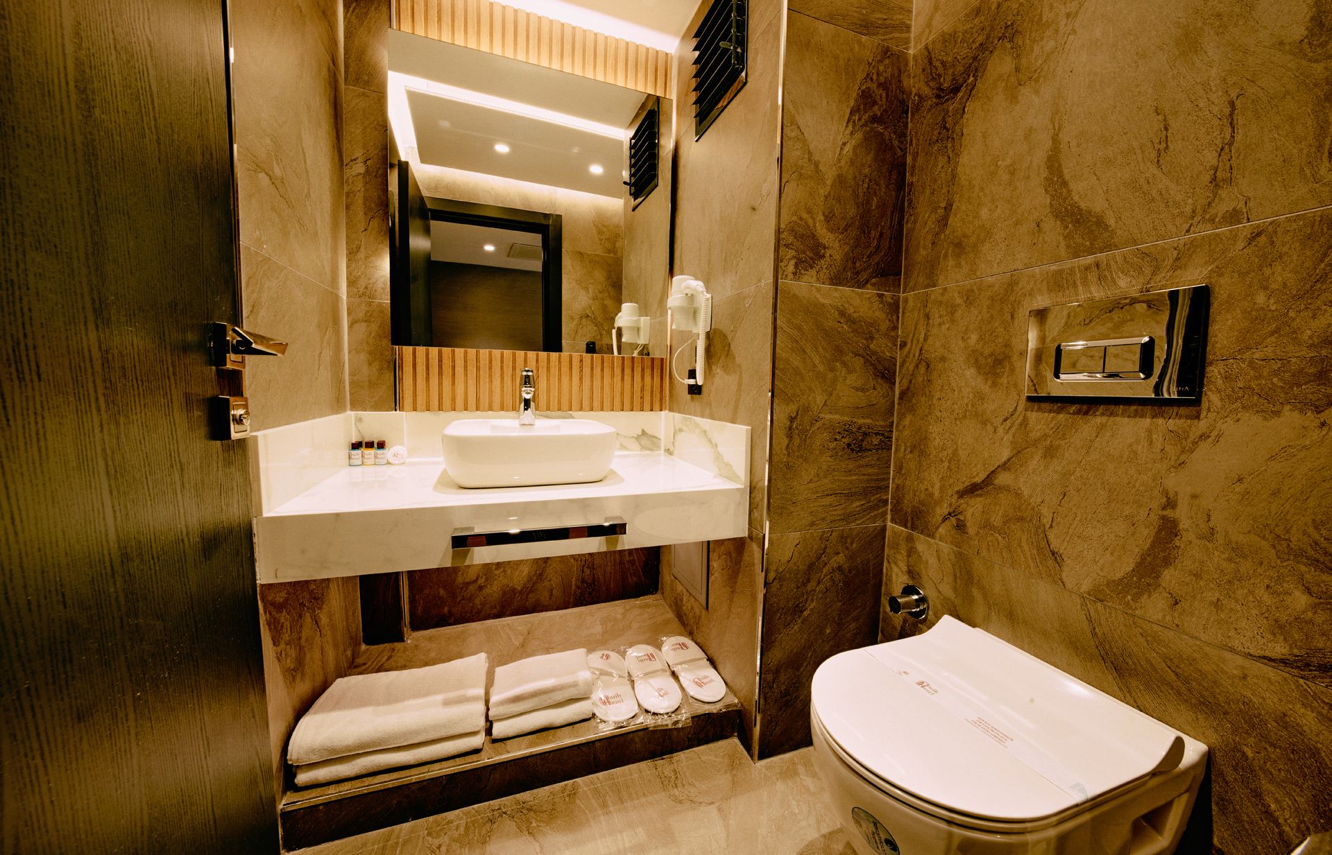 A bathroom with a toilet , sink and mirror.