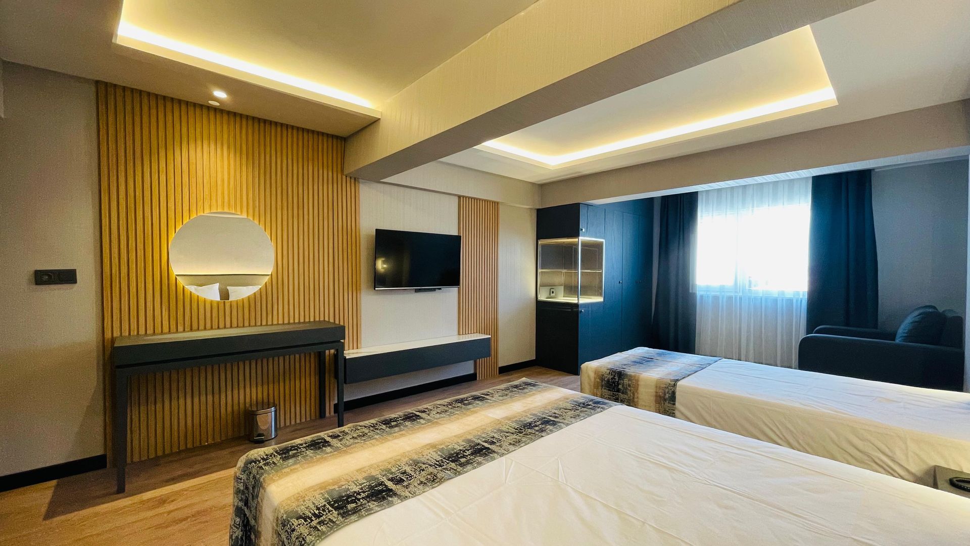 A hotel room with two beds , a television and a mirror.