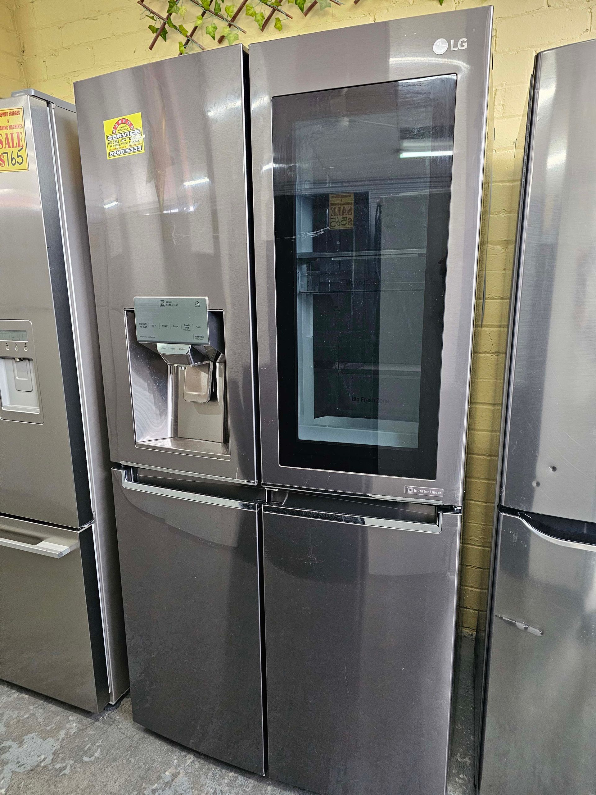 Stainless steel French-door refrigerator with water dispenser in a kitchen showroom