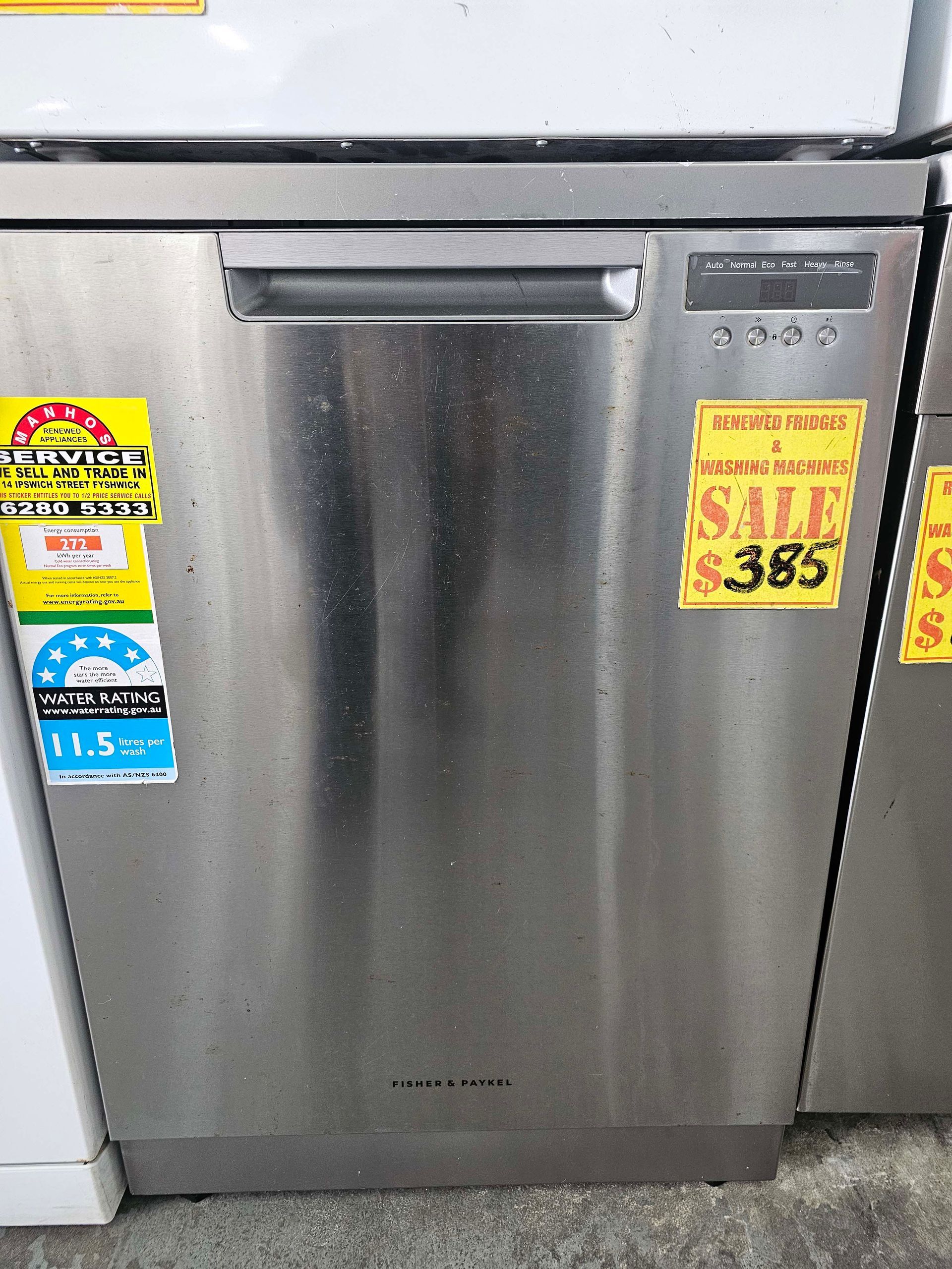 Stainless steel dishwasher with sale stickers in a store display.