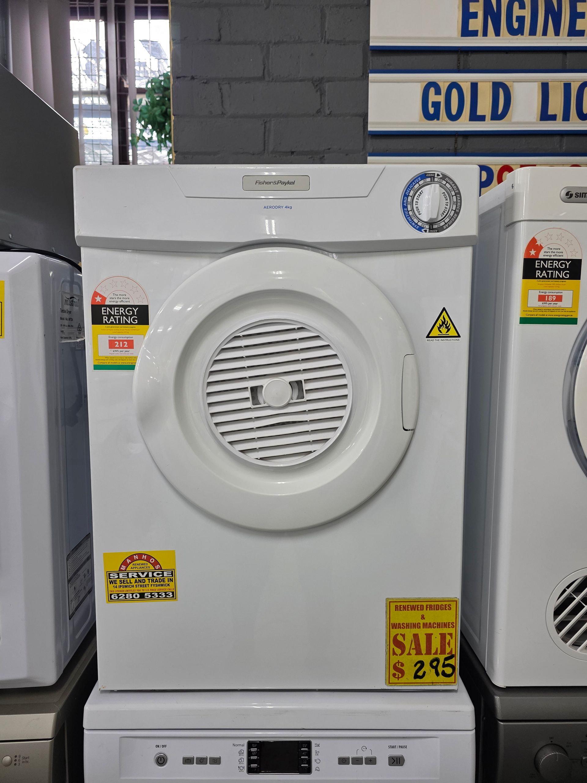 White clothes dryer with energy and sale labels.