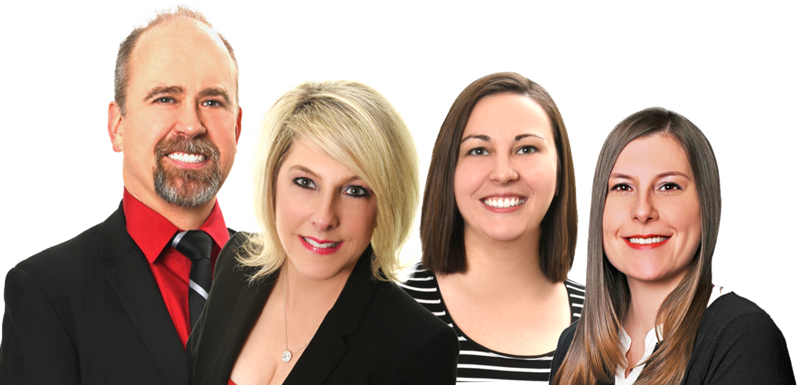Four professionally dressed people posed against a white background, smiling at the camera.