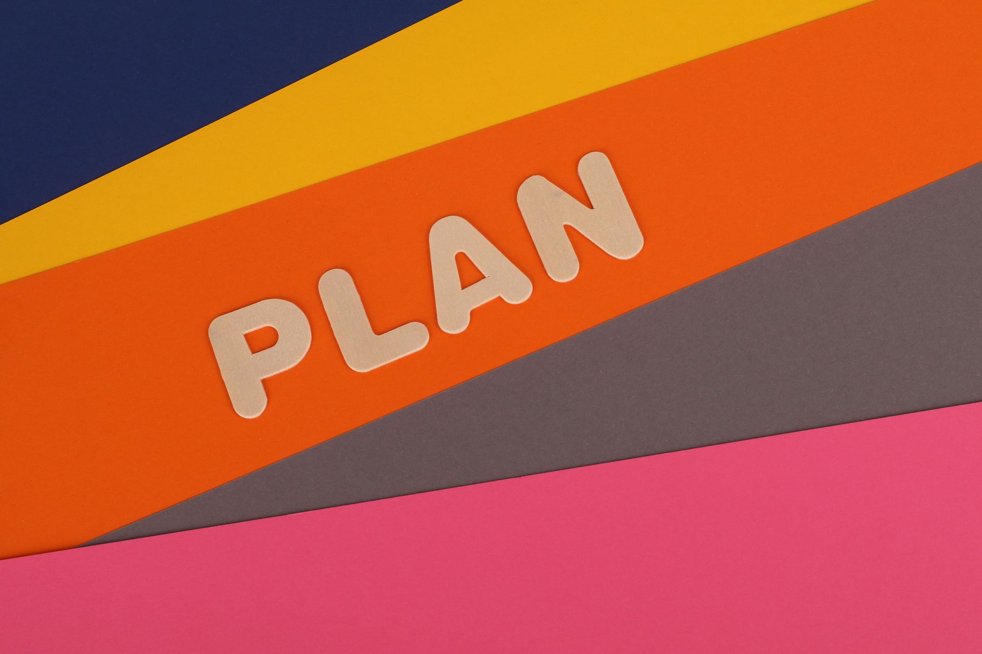 The word plan layered on top of stack of colored papers.
