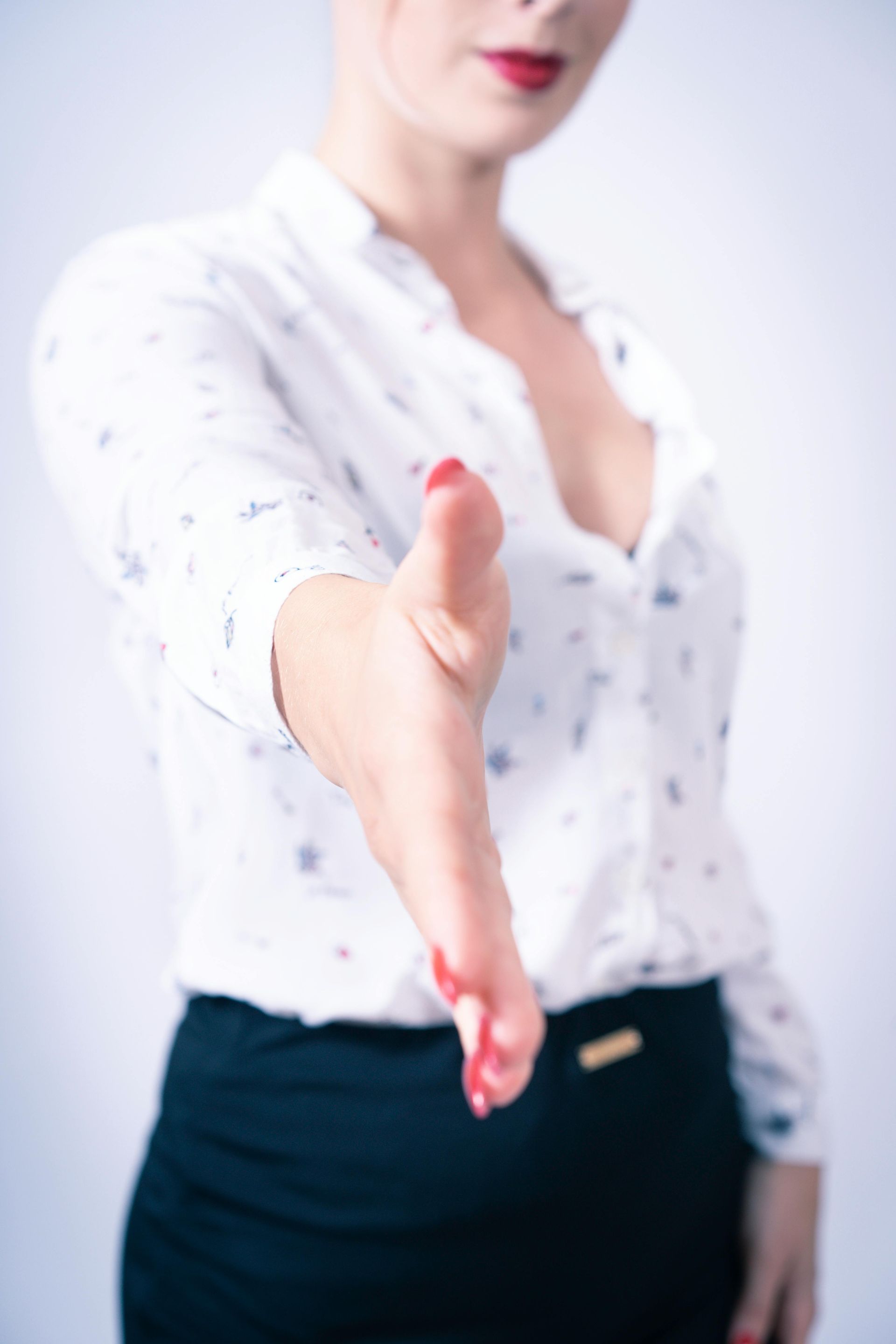 Hand extending a real estate offer to a home seller for consideration