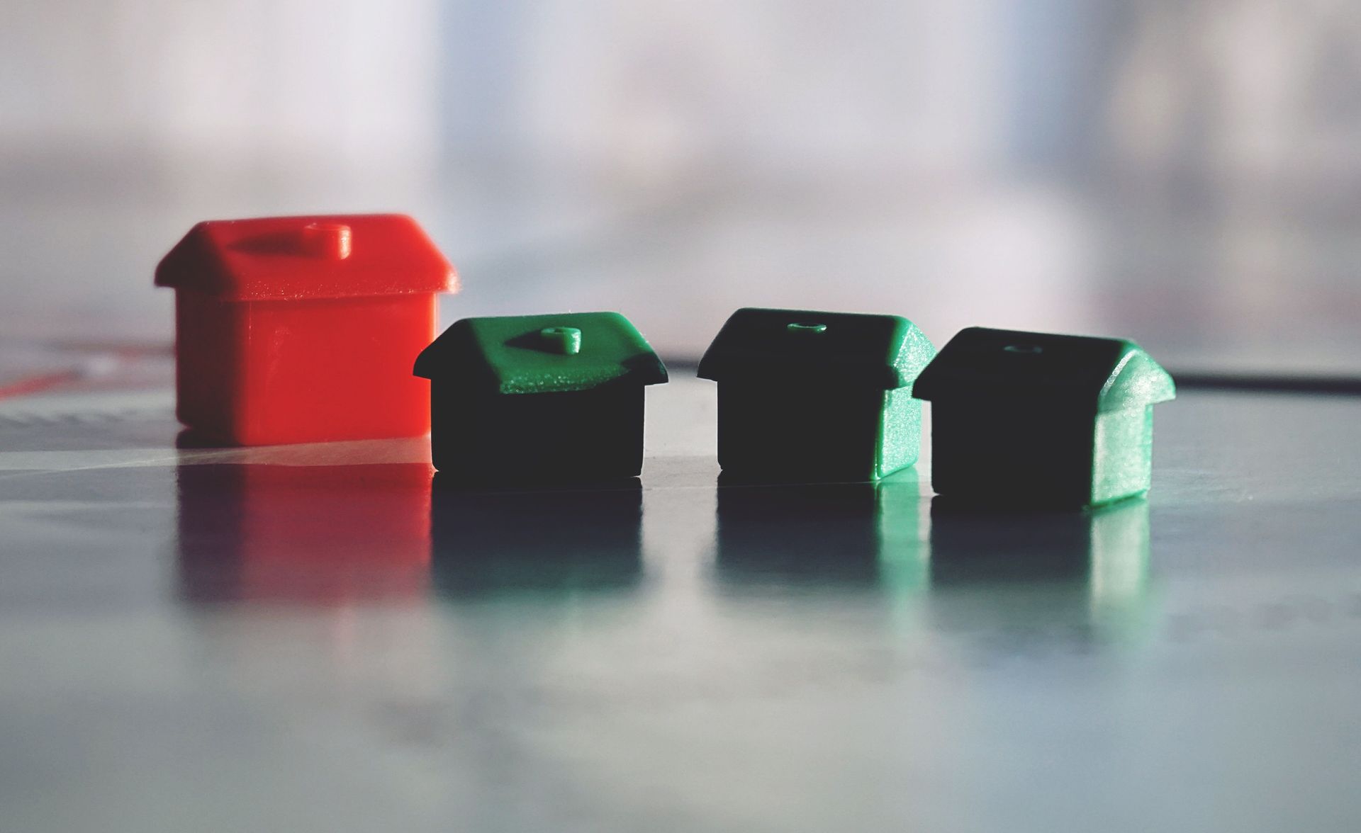 Monopoly Houses representing housing market; hotel to signify standing out against competition.