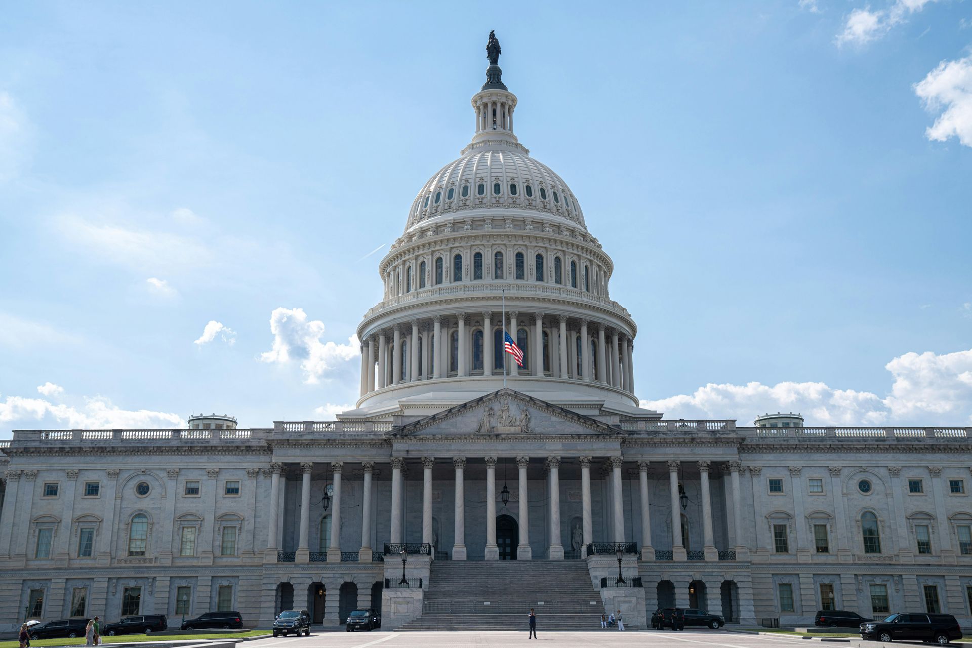 U.S. Capitol building with white dome and columns under a bright blue sky