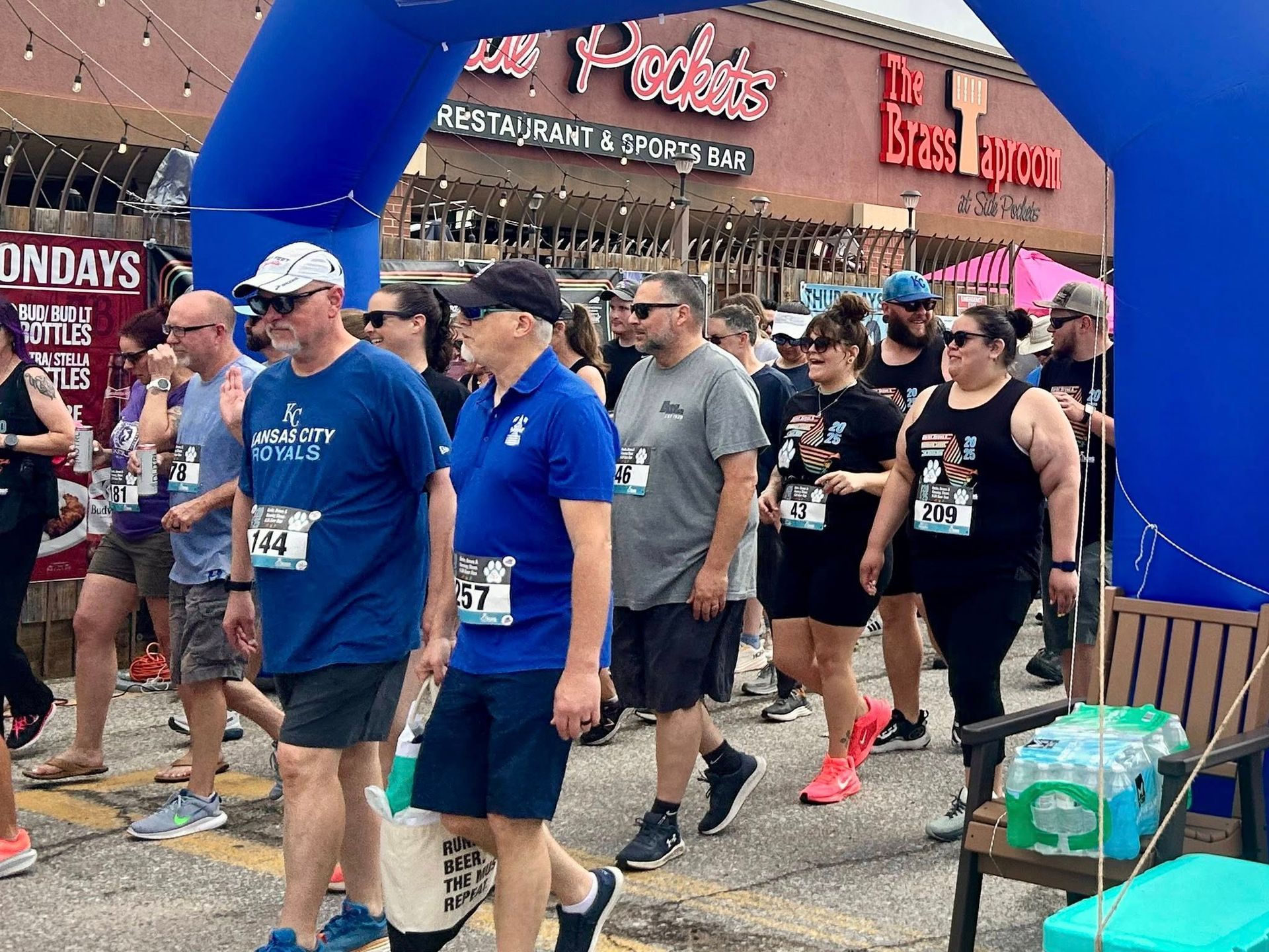 People  under a blue arch  at the start of a race 
