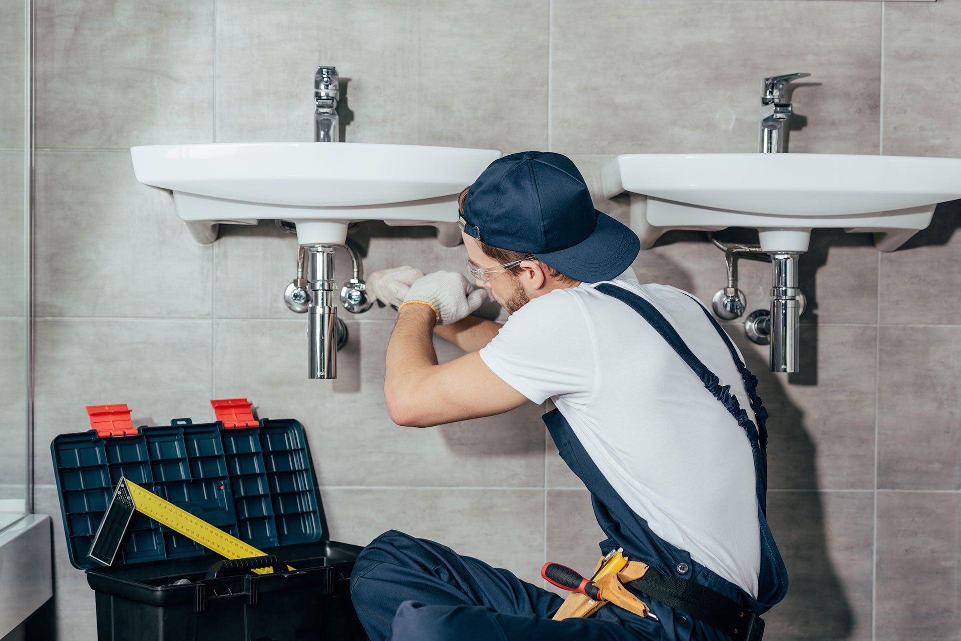 plumber with tool box installing his and hers sinks