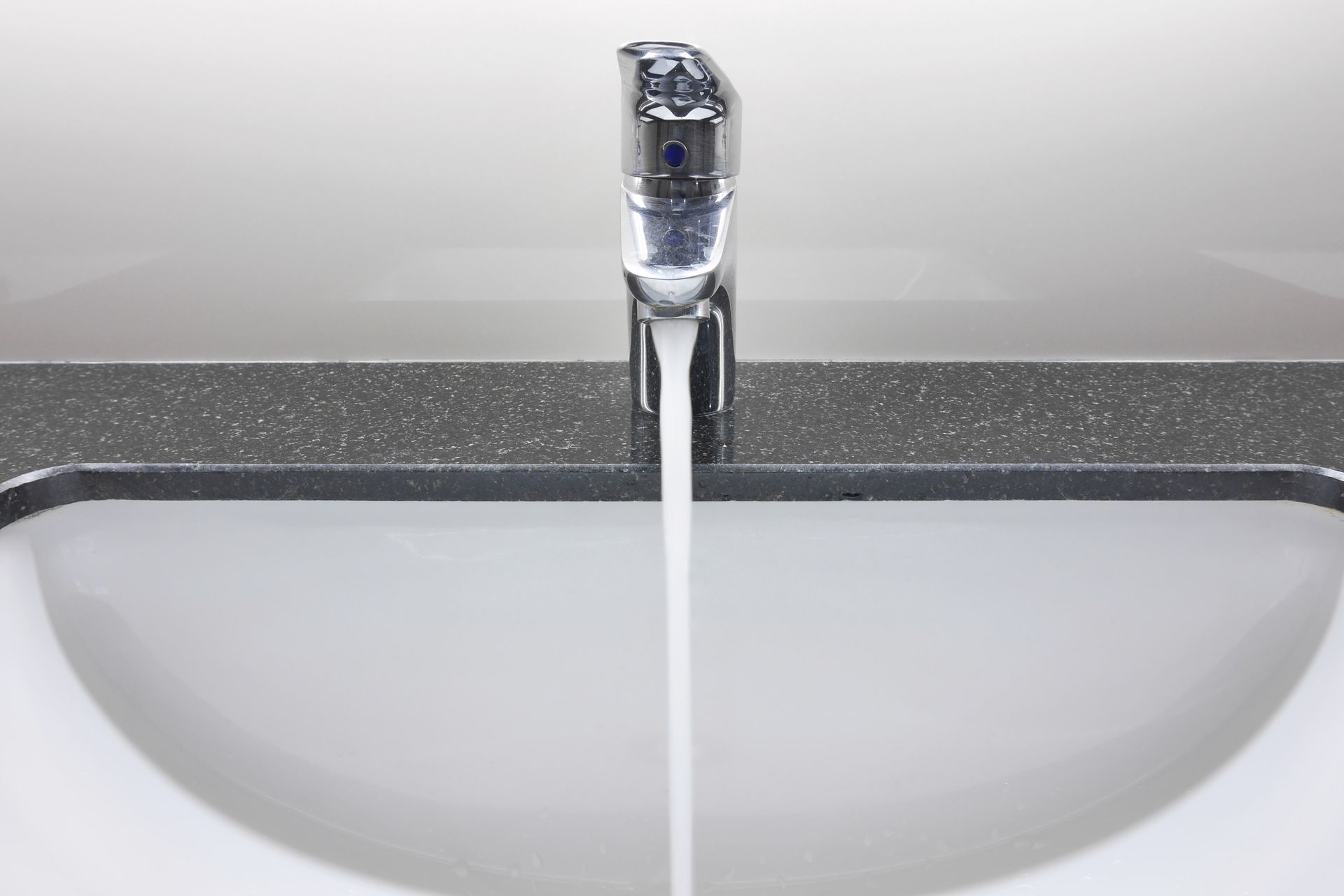 A bathroom sink with water running from the faucet