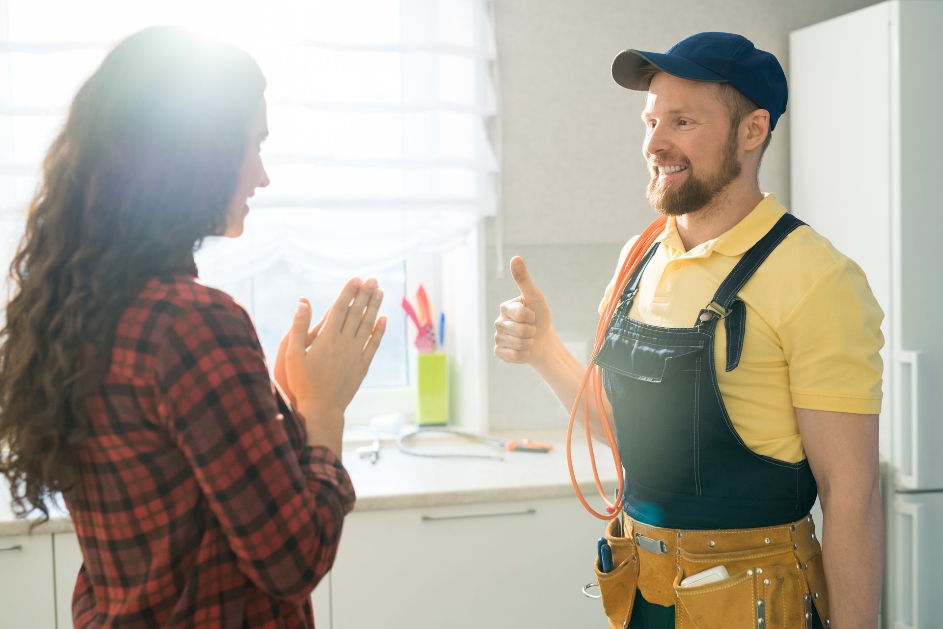 A man is giving a thumbs up to a woman in a kitchen.