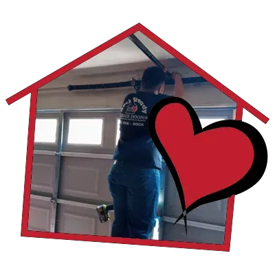 A man is working on a garage door with a heart in the background