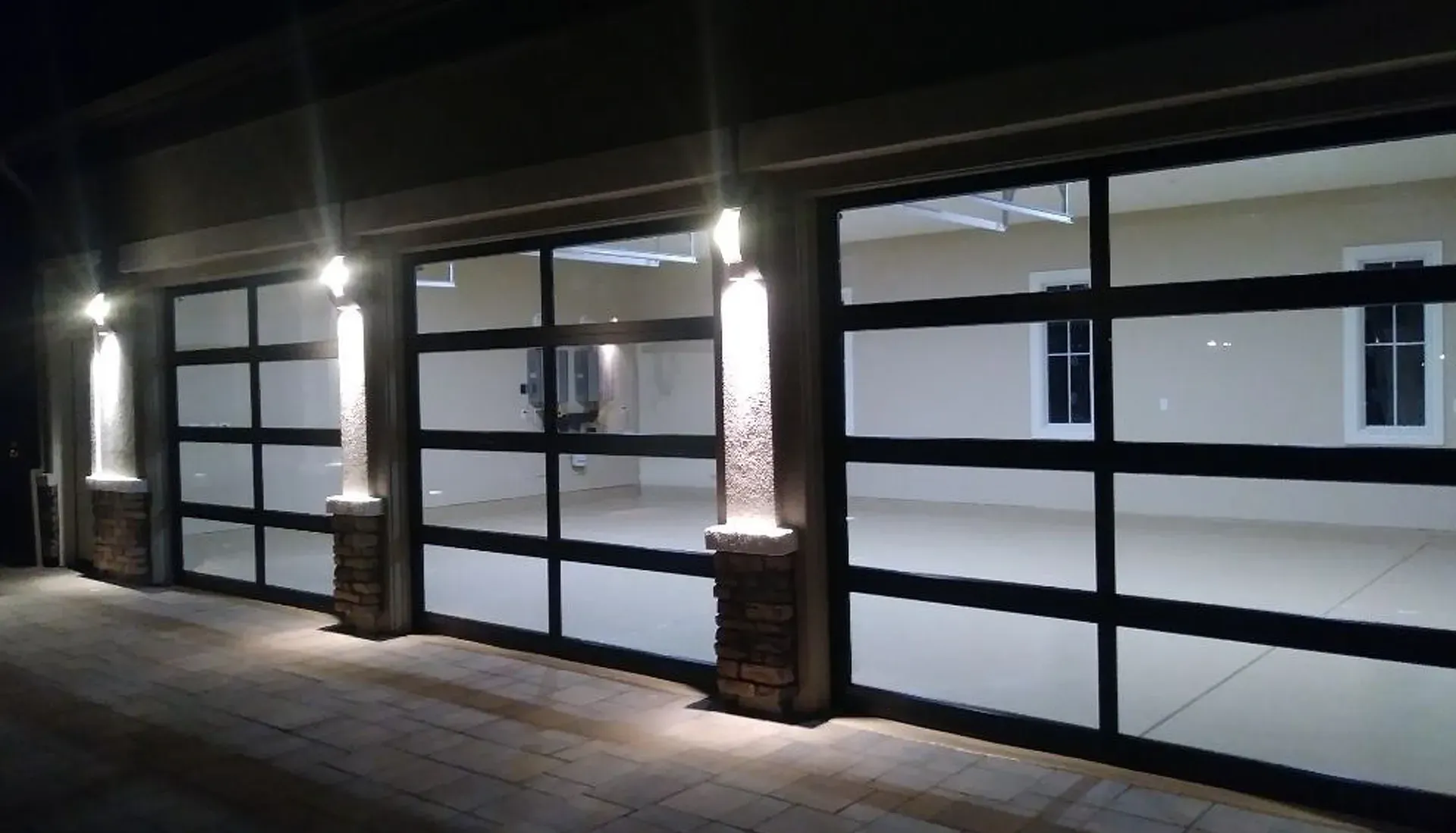 A row of garage doors are lit up at night