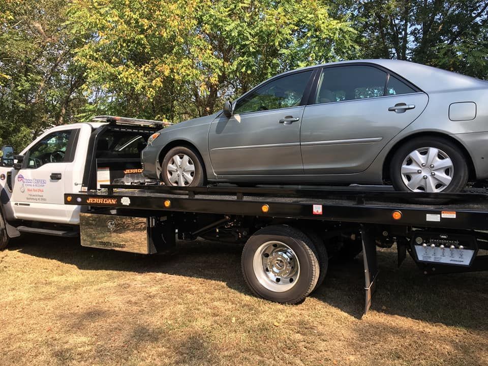 A car is sitting on top of a tow truck.