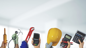 Hand tools, a multimeter, and a yellow hard hat held up against a bright background