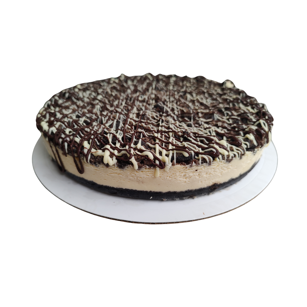 Tarta de queso y chocolate sobre un plato blanco, cubierta con chocolate y llovizna blanca de Azúcar y Cacao