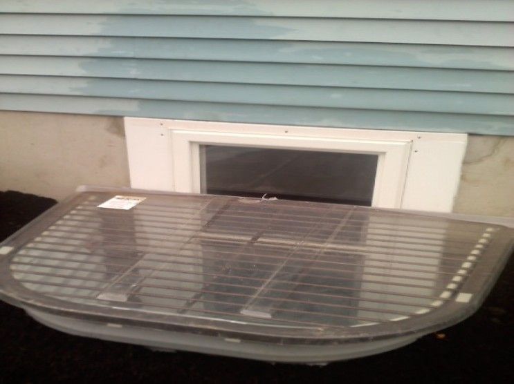A clear plastic container is sitting in front of a window.