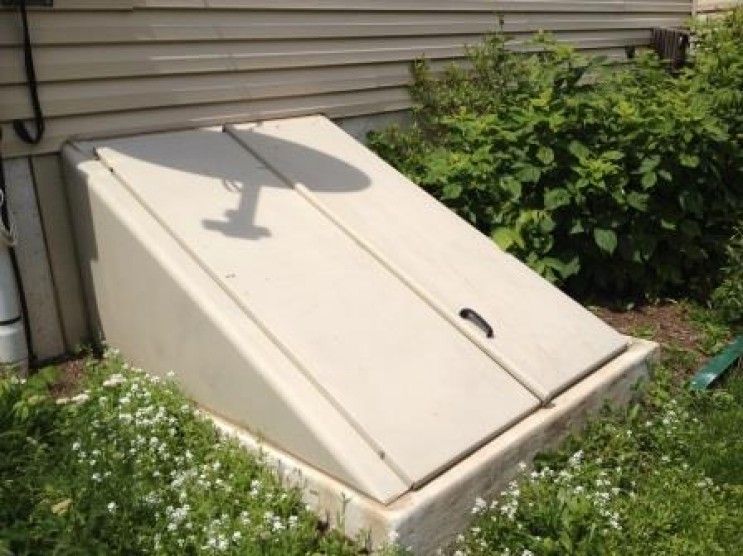 A white box is sitting in the grass next to a house