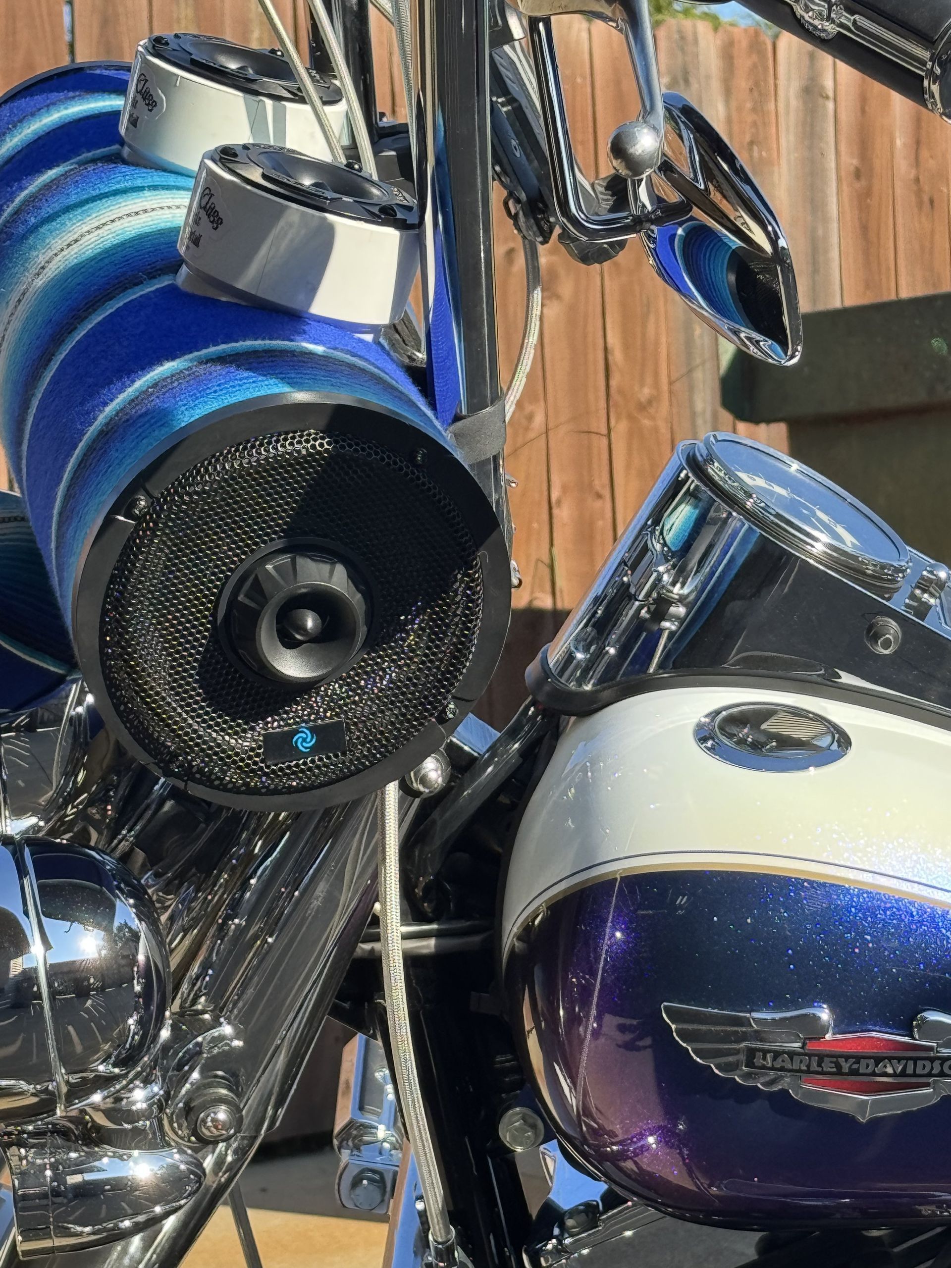 Blue touring motorcycle parked in a garage, with a black seat and chrome details.