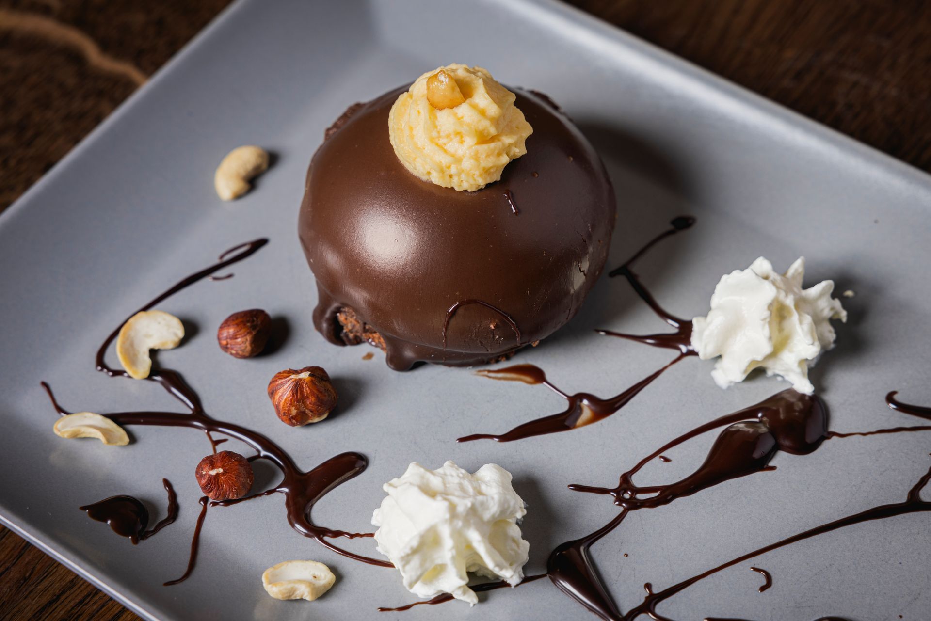Ein Schokoladendessert mit Schlagsahne und Nüssen auf einem Teller