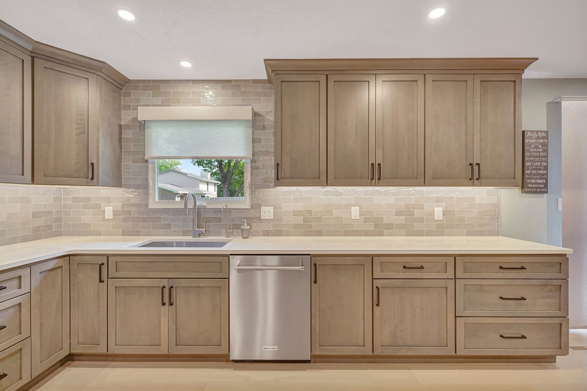 Kitchen with light brown cabinets, stainless steel appliances, and a tiled backsplash.