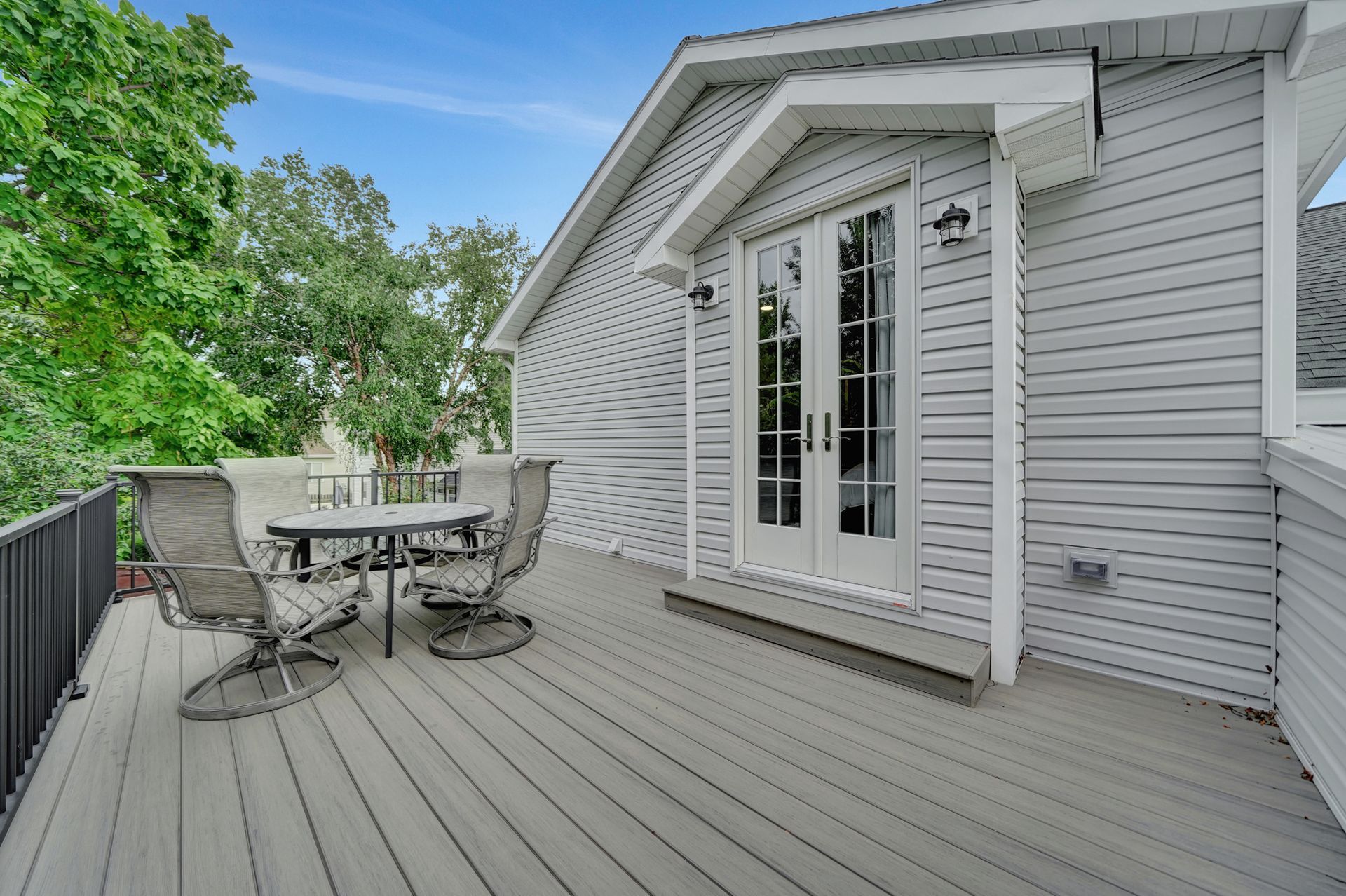 There is a large deck with a table and chairs on it.