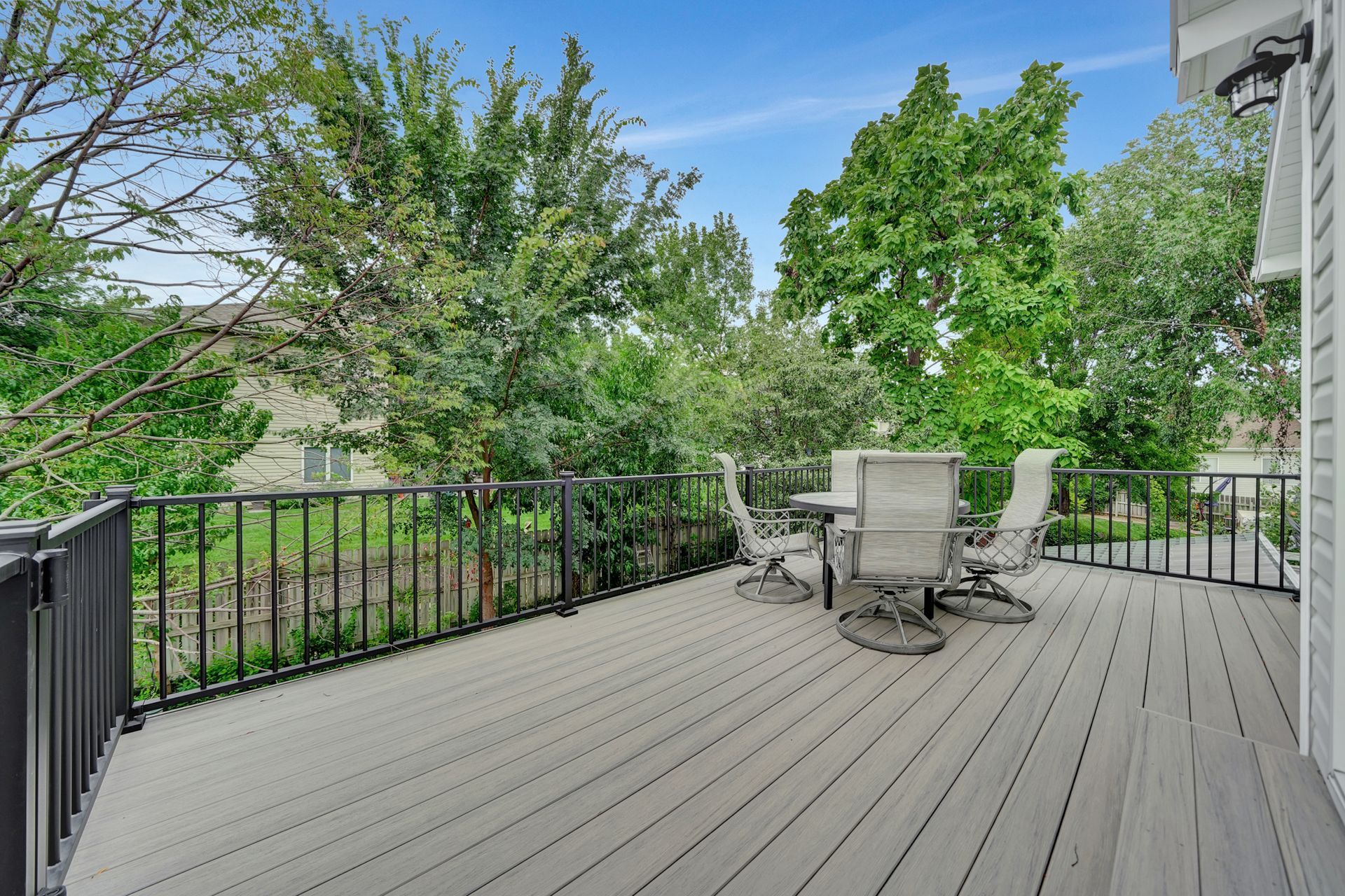 There is a large deck with a table and chairs on it.