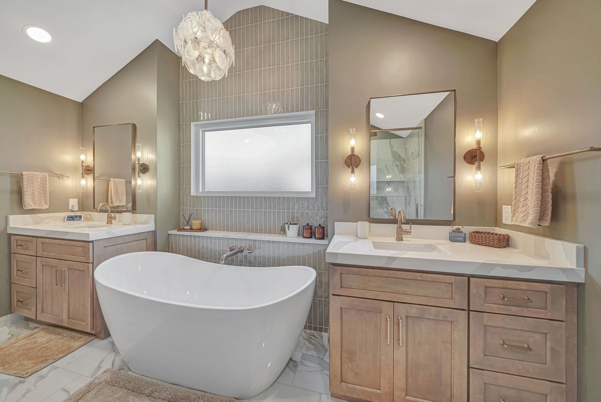 Luxurious modern bathroom with a freestanding tub, dual vanities, and warm-toned walls.