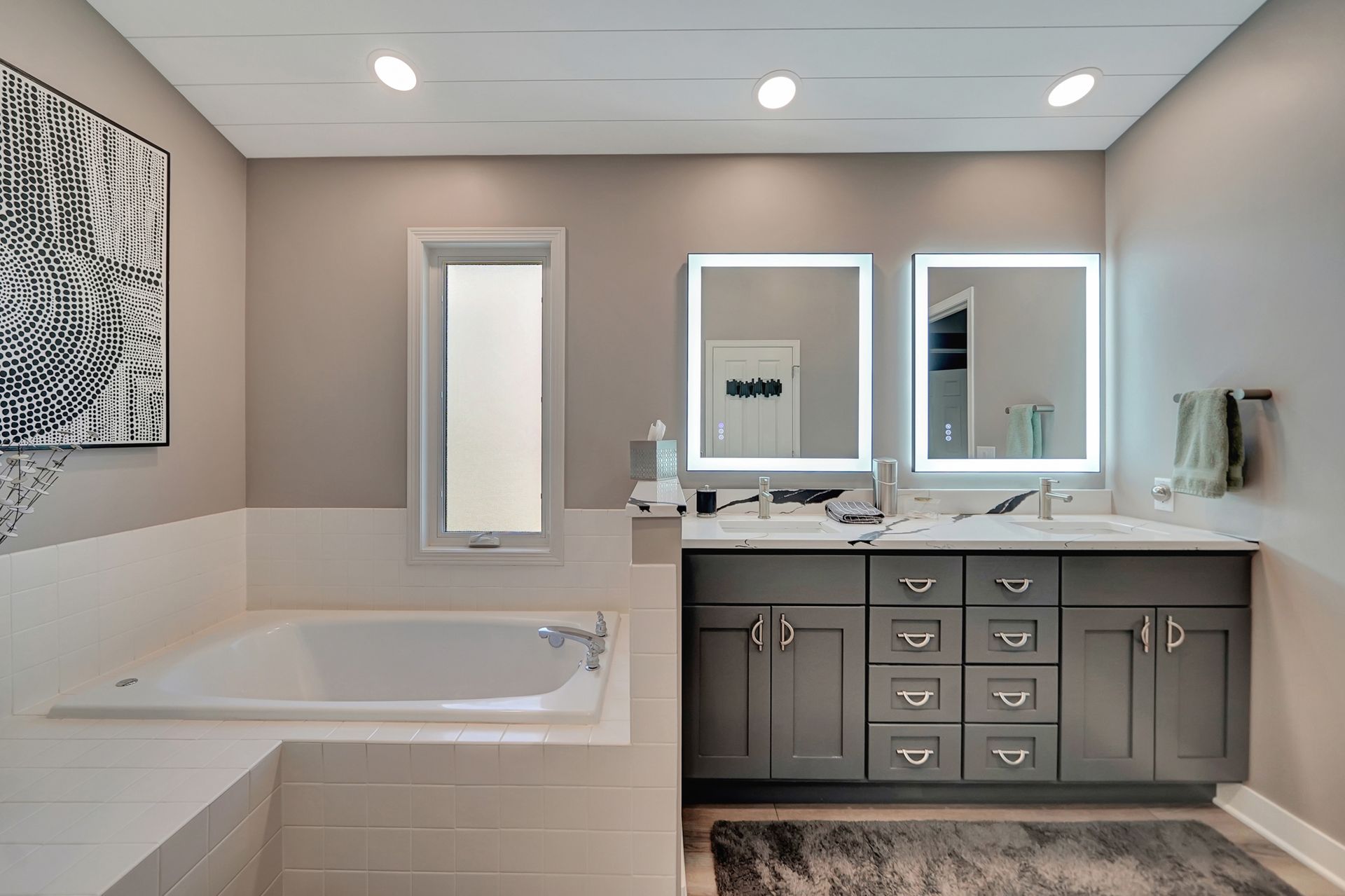 Modern bathroom with a bathtub, double vanity, and a neutral color scheme.