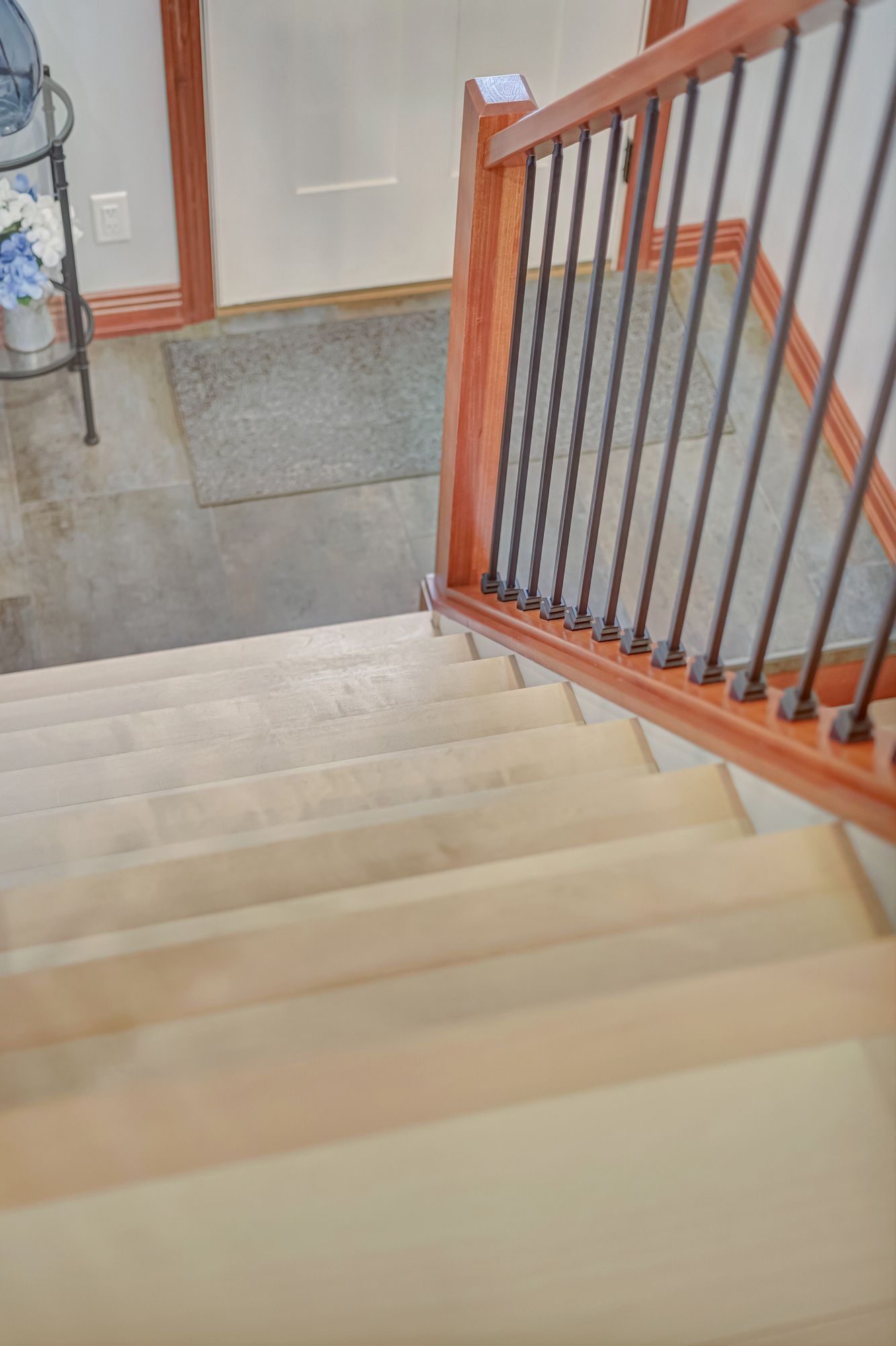 Staircase with carpeted steps and wooden railing. Downward perspective.
