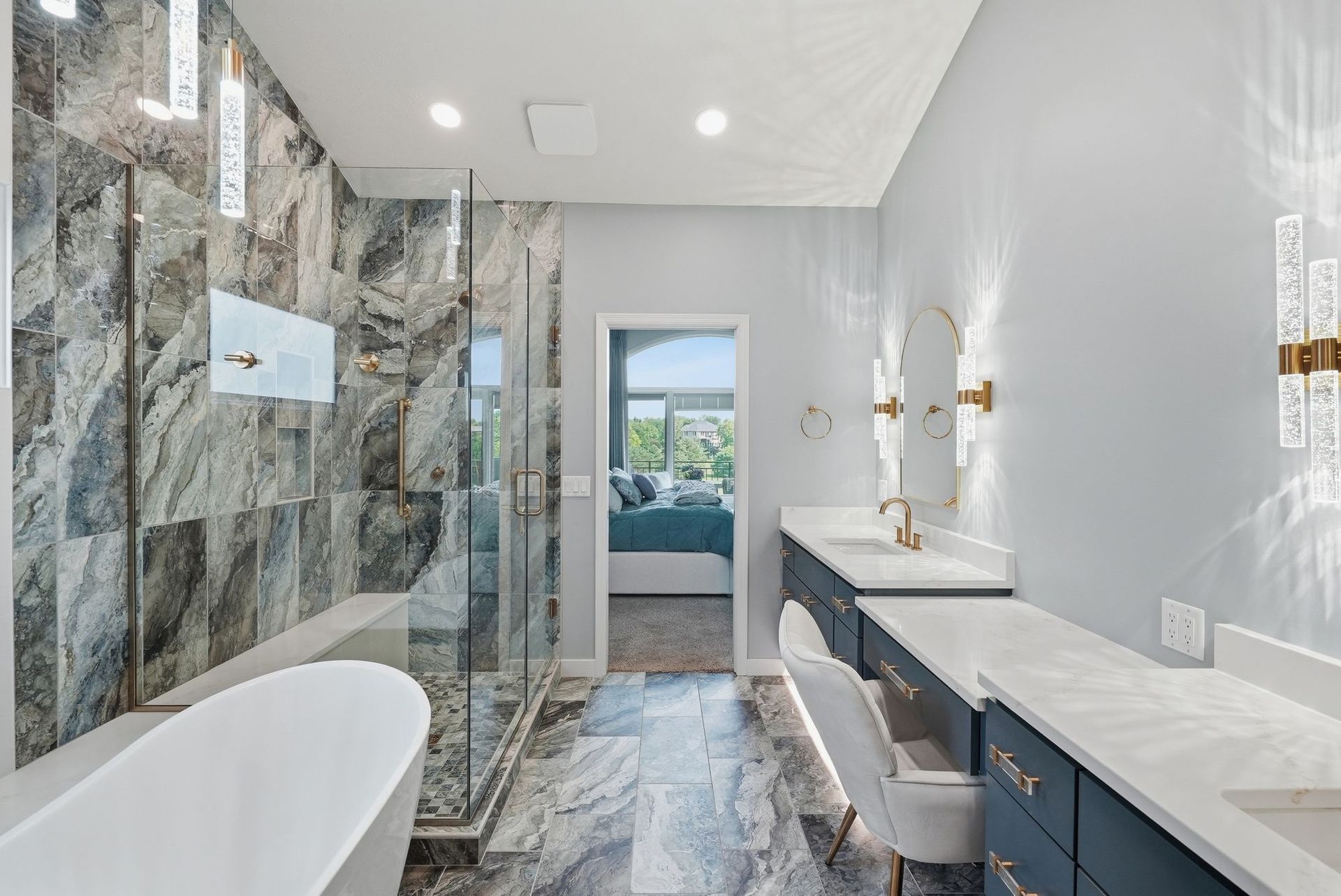 Modern bathroom with marble shower, freestanding tub, double vanity, and bench seat