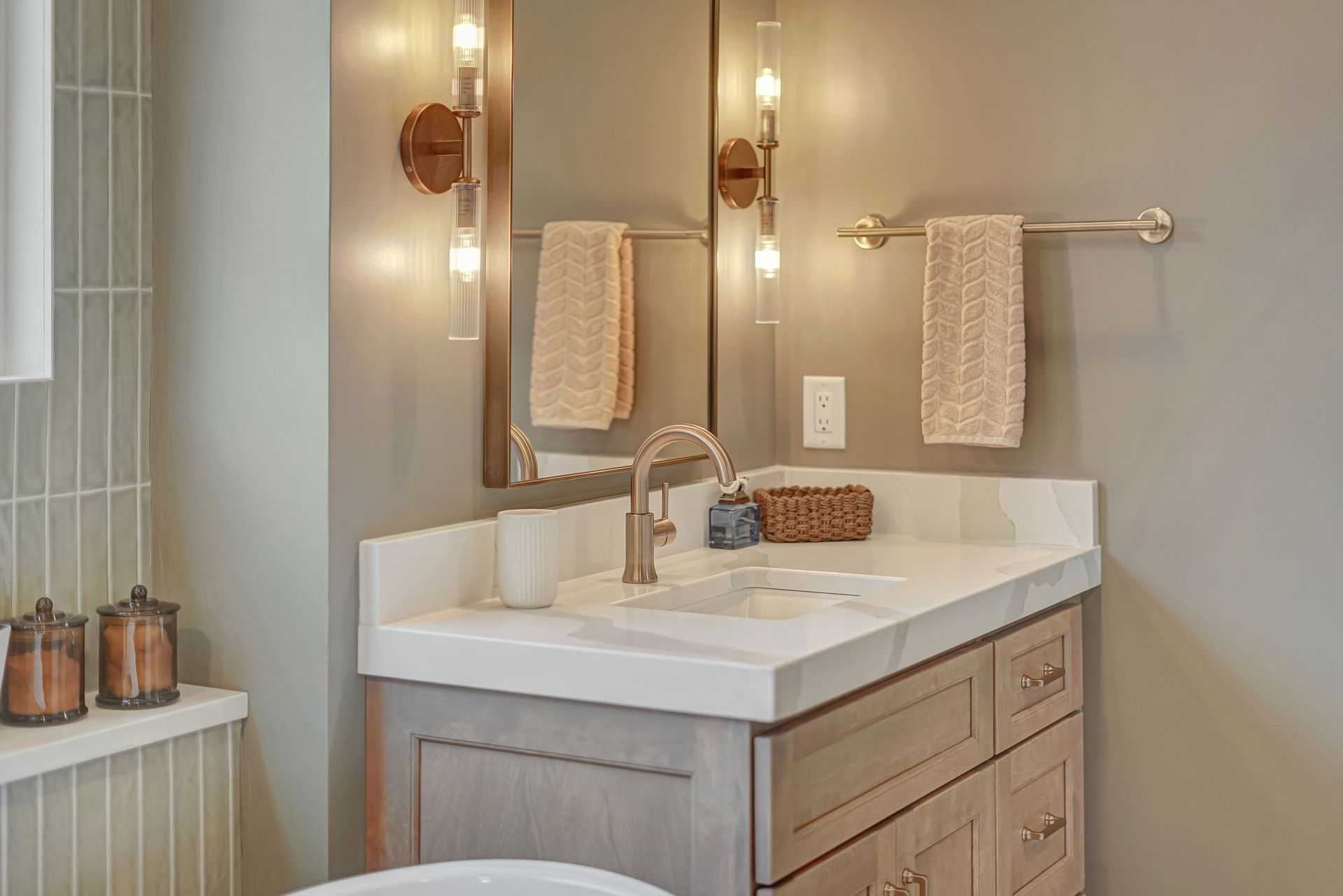 Bathroom with double sink vanity, mirror, sconces, and neutral color scheme.