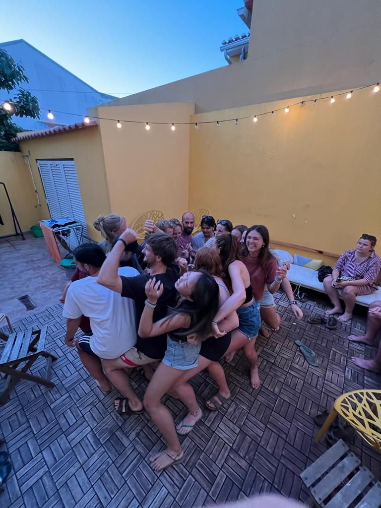 A group of people are standing in a circle on a brick floor.
