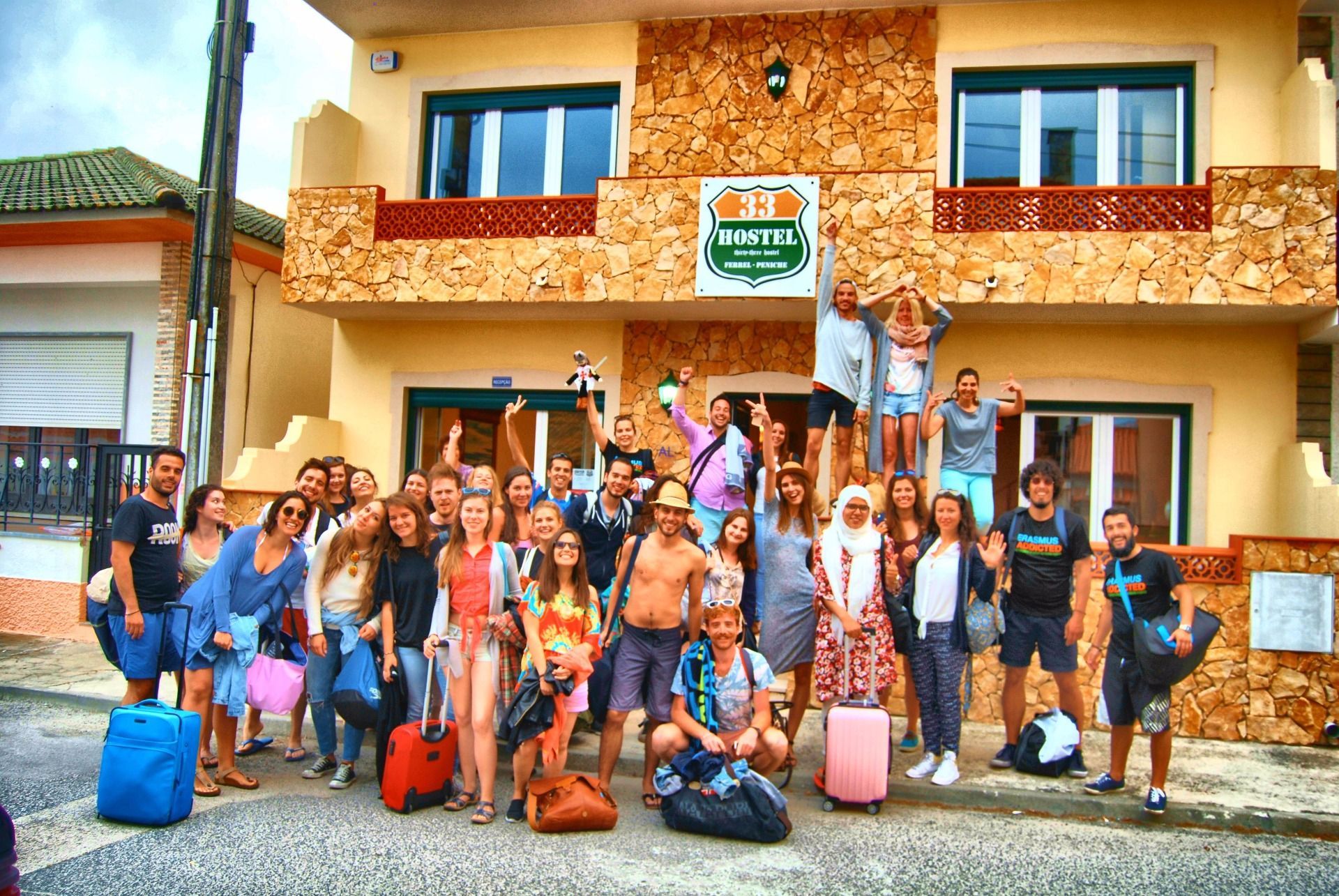 A group of people standing in front of a building that says hostel
