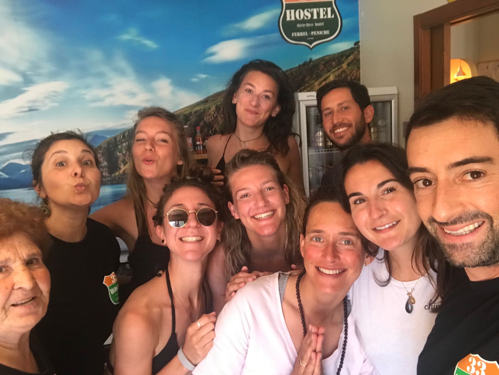 A group of people are posing for a picture in front of a hostel sign.
