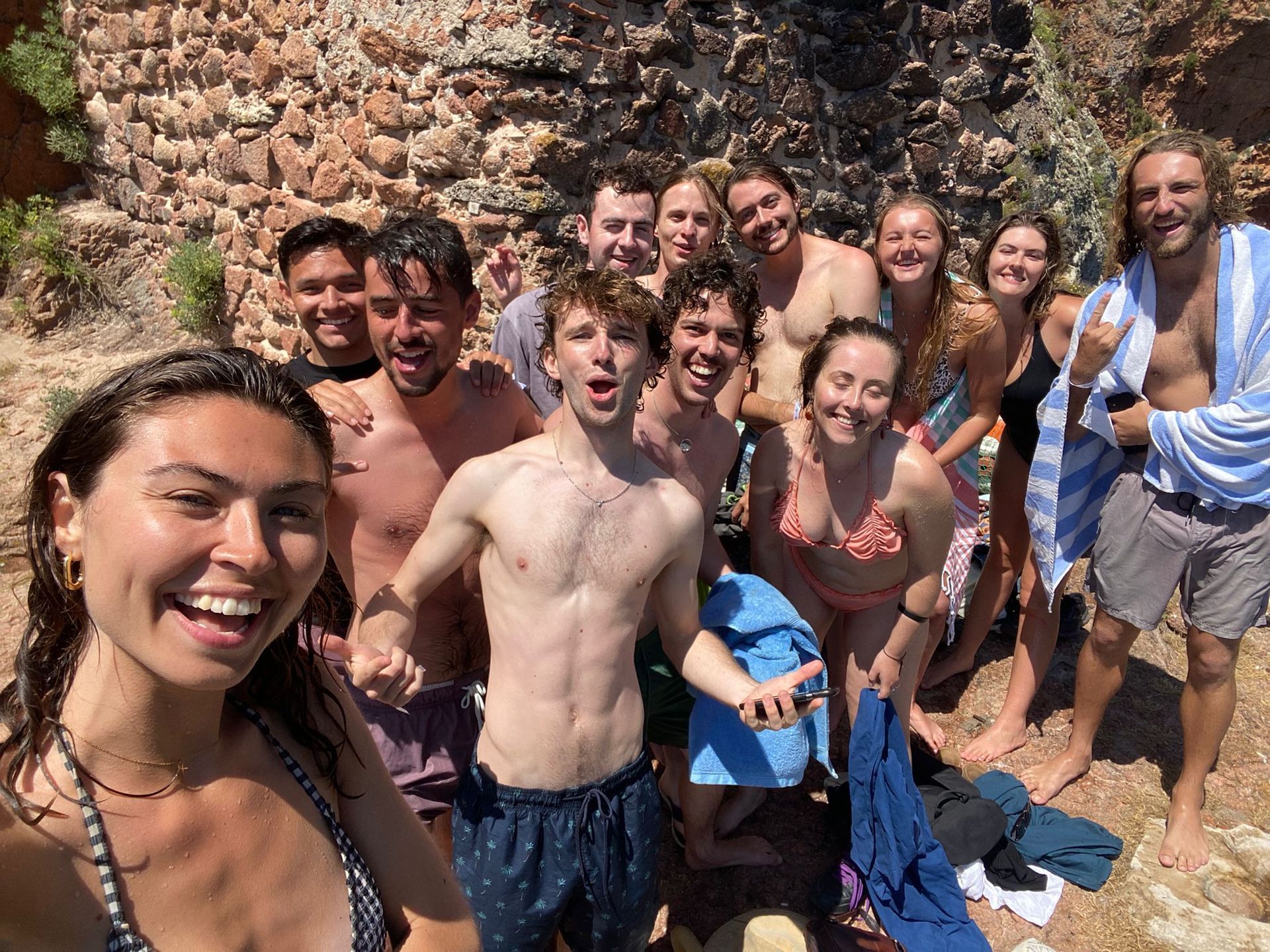 A group of people are posing for a picture on a beach.