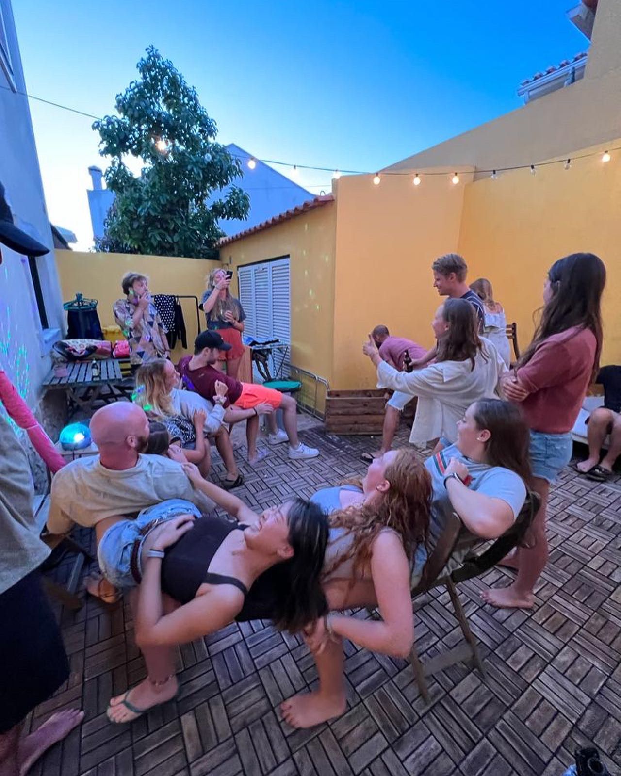 A group of people are sitting in chairs on a patio.