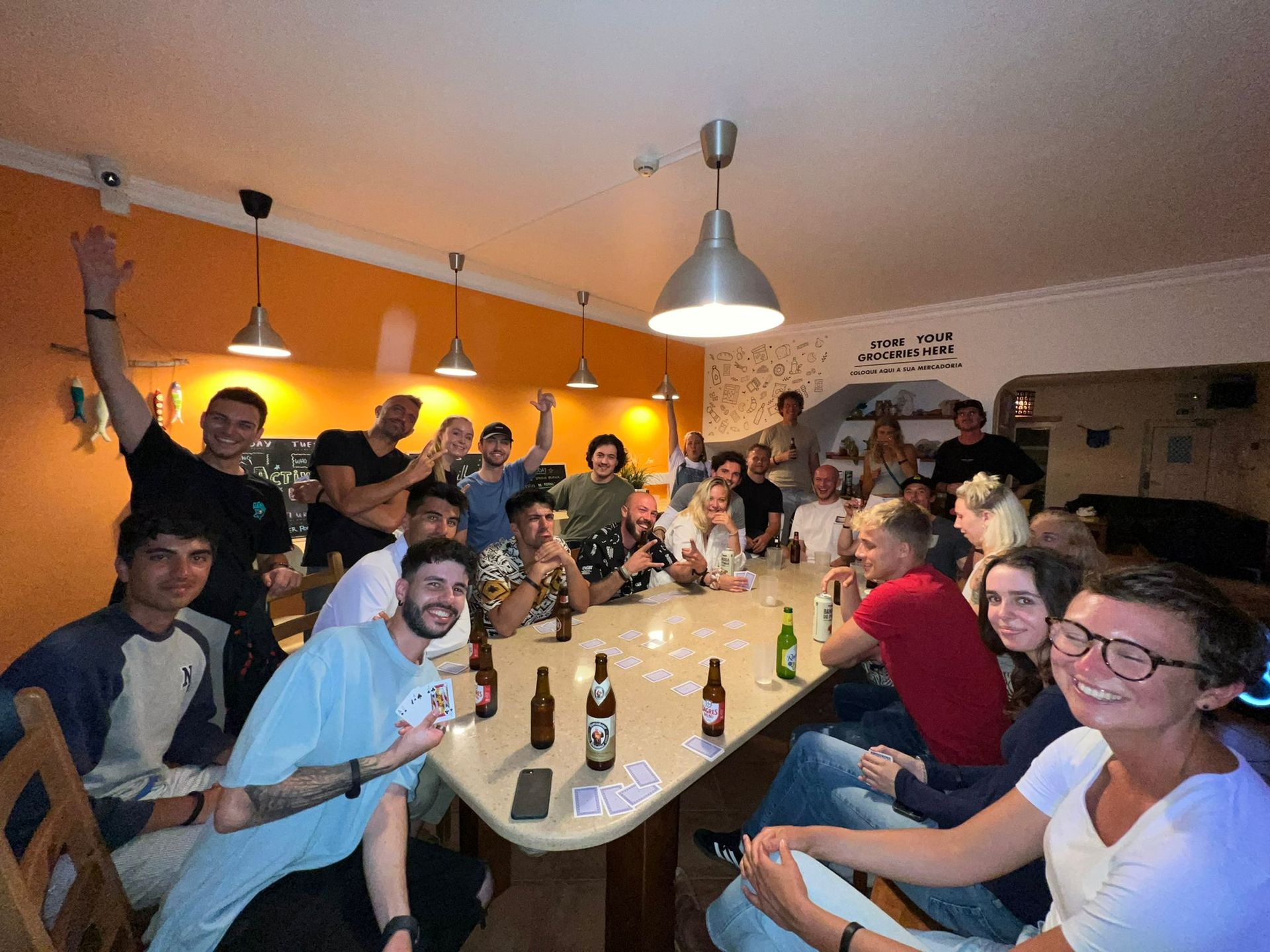 A group of people are sitting around a table with bottles of beer.