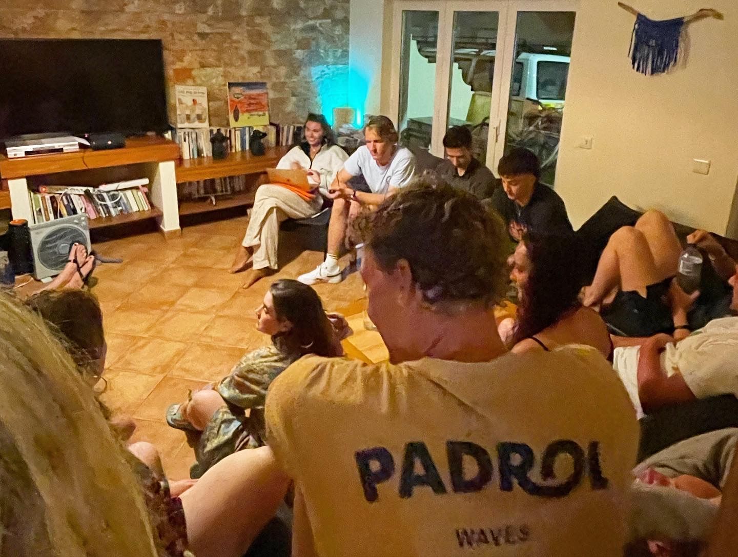 A group of people are sitting in a circle in a living room.