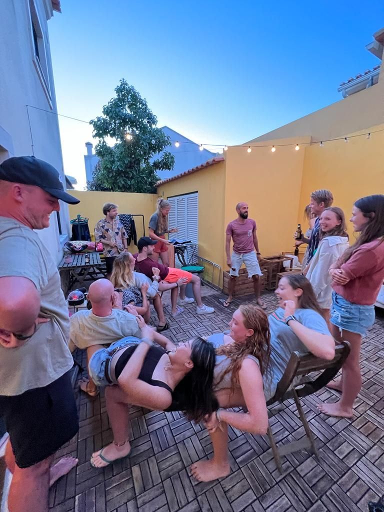 A group of people are standing around a woman sitting on a chair.