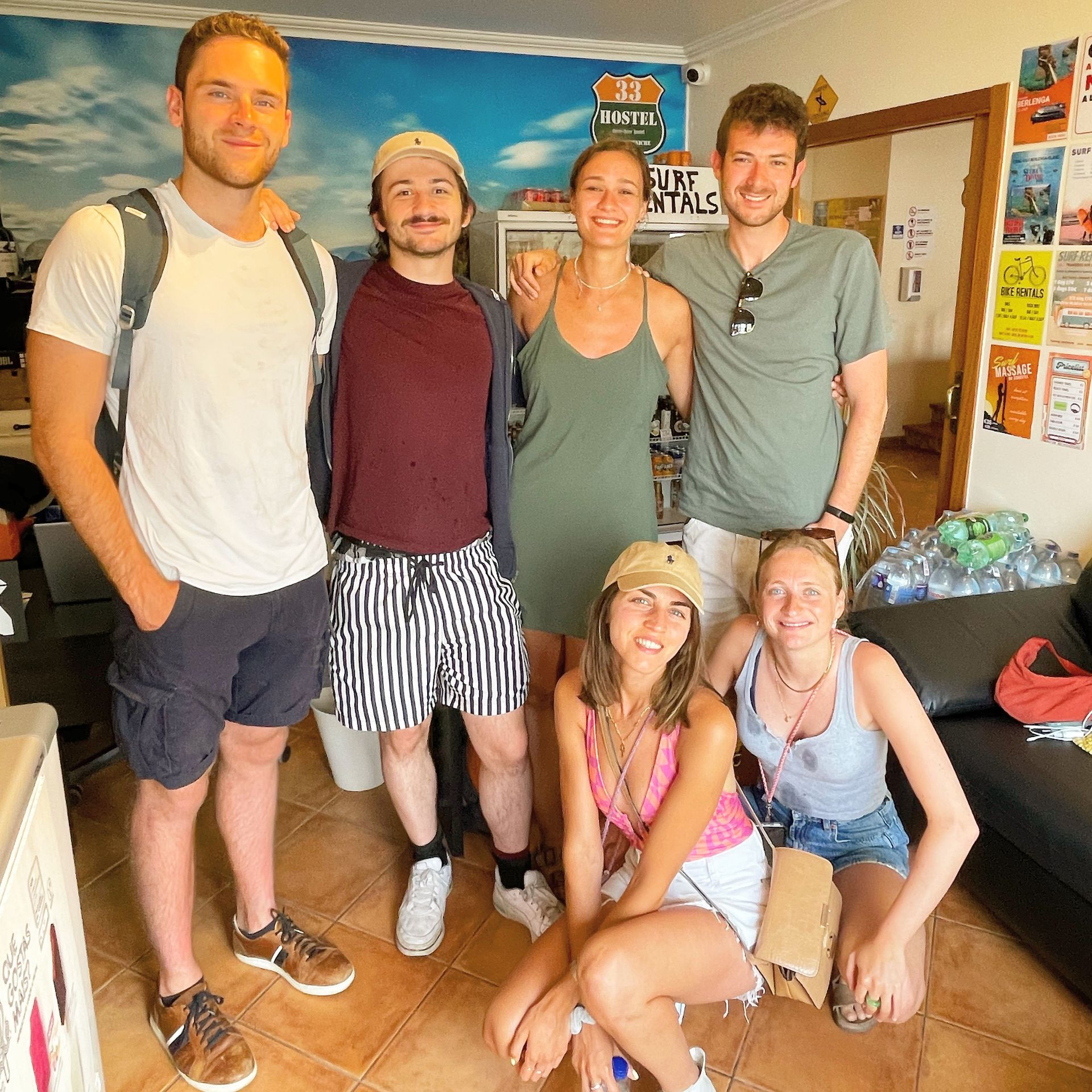 A group of people posing for a picture in front of a sign that says surf rentals